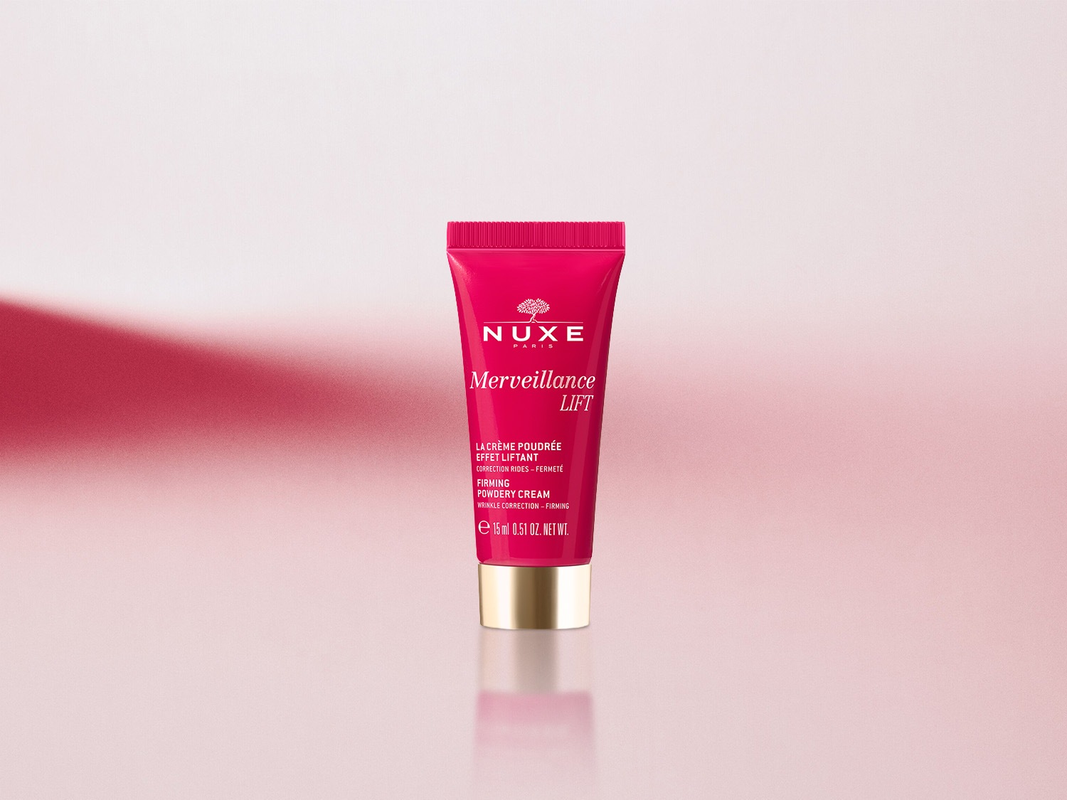 Nahaufnahme einer rosafarbenen Tube Nuxe Merveillance Lift Straffungscreme zur Faltenkorrektur mit goldenem Deckel.