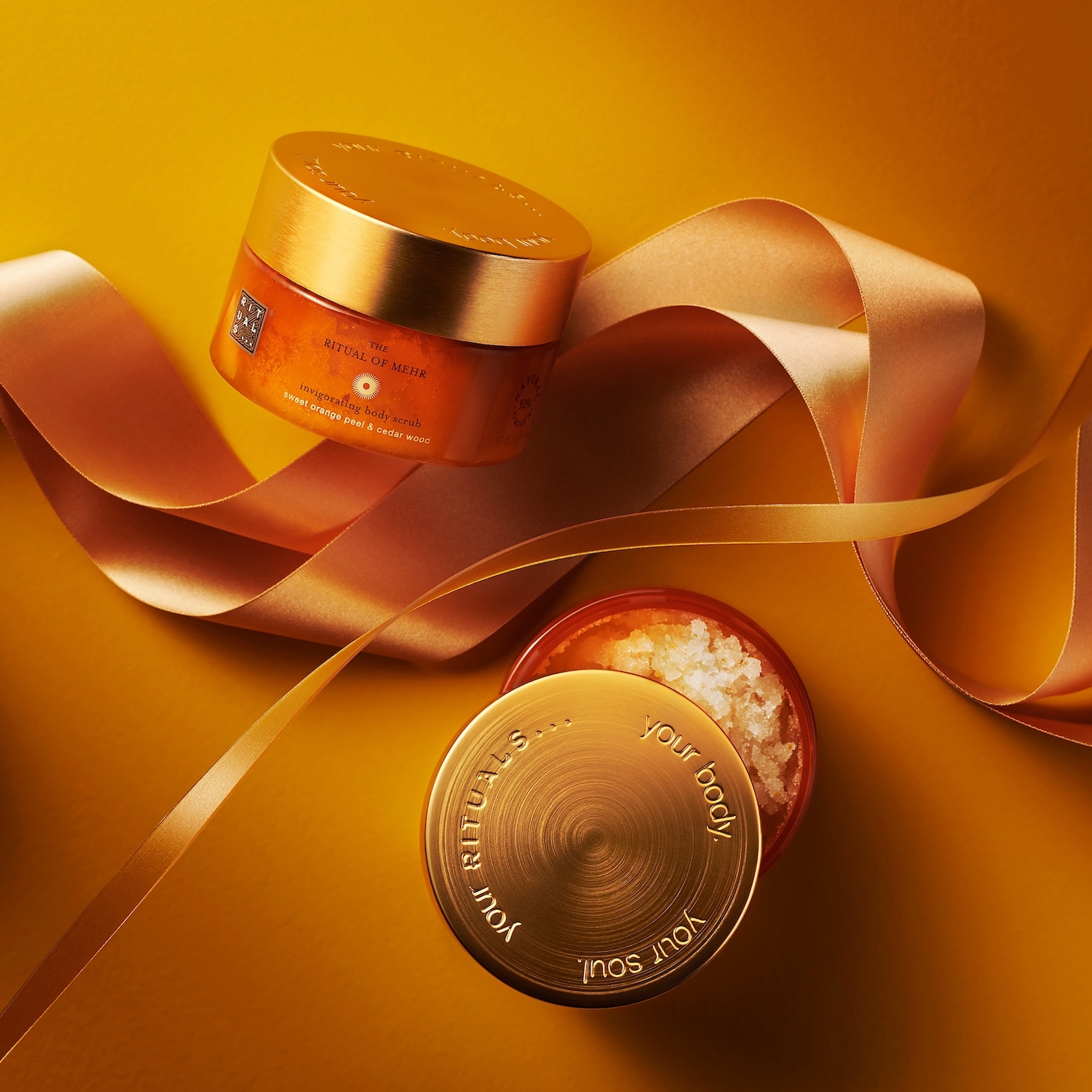 Entdecke das Ritual of Mehr Körperpeeling von Rituals, angereichert mit Süßorange und Zedernholz, präsentiert in einer goldenen Verpackung, die Körper und Seele verwöhnt.