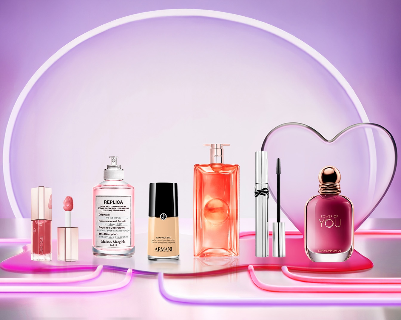 Eine Auswahl an Schönheitsprodukten, darunter Lancôme Lipgloss, Replica Parfüm, Armani Foundation, Lancôme Parfüm, YSL Mascara und Emporio Armani Parfüm, die auf einer glänzenden Oberfläche vor einem violetten Hintergrund präsentiert werden.