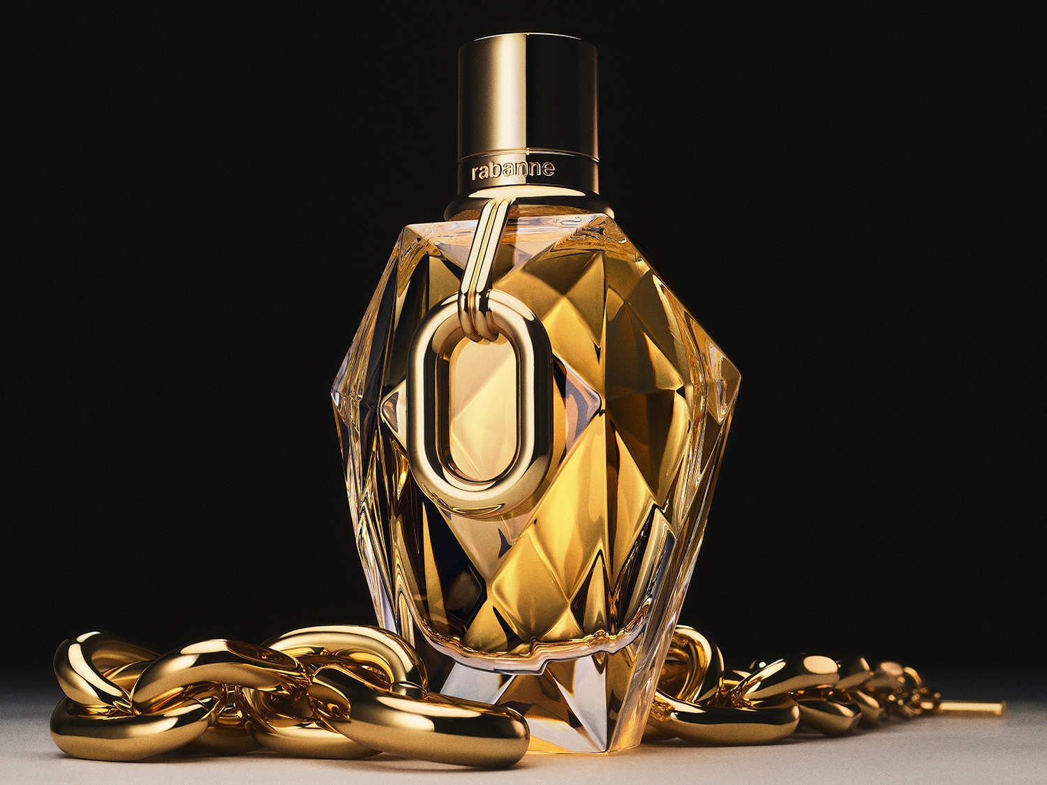 Funkelnder, goldener Flakon von Rabanne mit einem auffälligen goldenen Kettenakzent, der Luxus und Eleganz ausstrahlt.