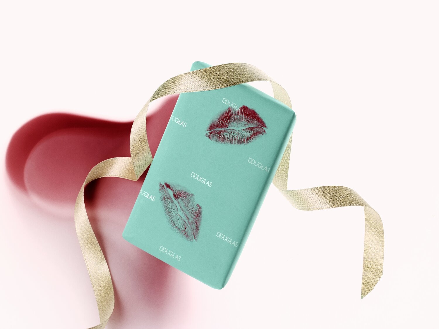 Hellblaue Douglas-Geschenkverpackung mit roten Kussabdrucken und goldener Schleife, die einen Hauch von Romantik und Eleganz für ein besonderes Geschenk verleiht.