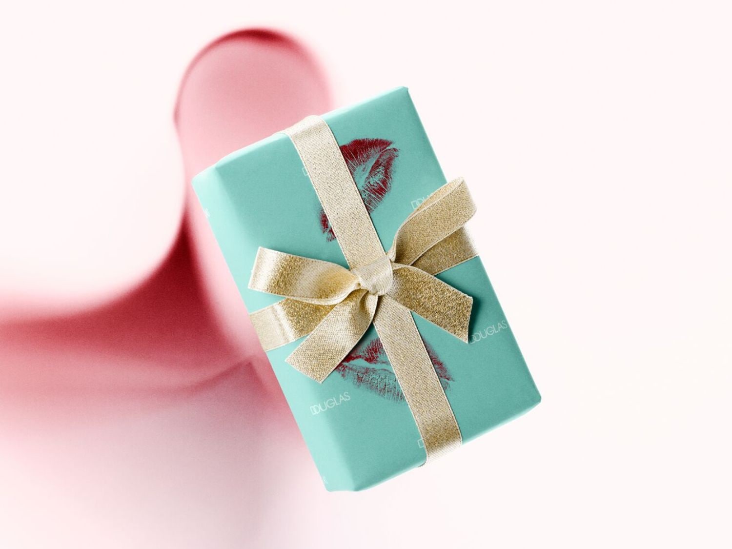 Egy türkizkék Douglas ajándékdoboz arany szalaggal átkötve, piros rúzsnyomokkal díszítve, tökéletes meglepetés bármilyen alkalomra.