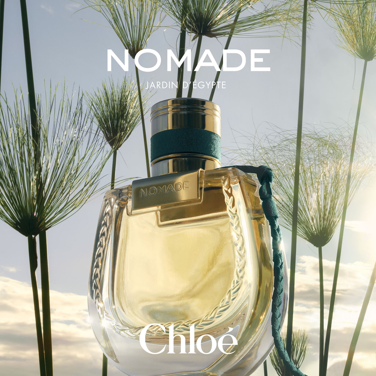 Découvrez Nomade Jardin d'Égypte de Chloé, un parfum lumineux dans un flacon élégant orné de détails dorés et d'un cordon bleu.