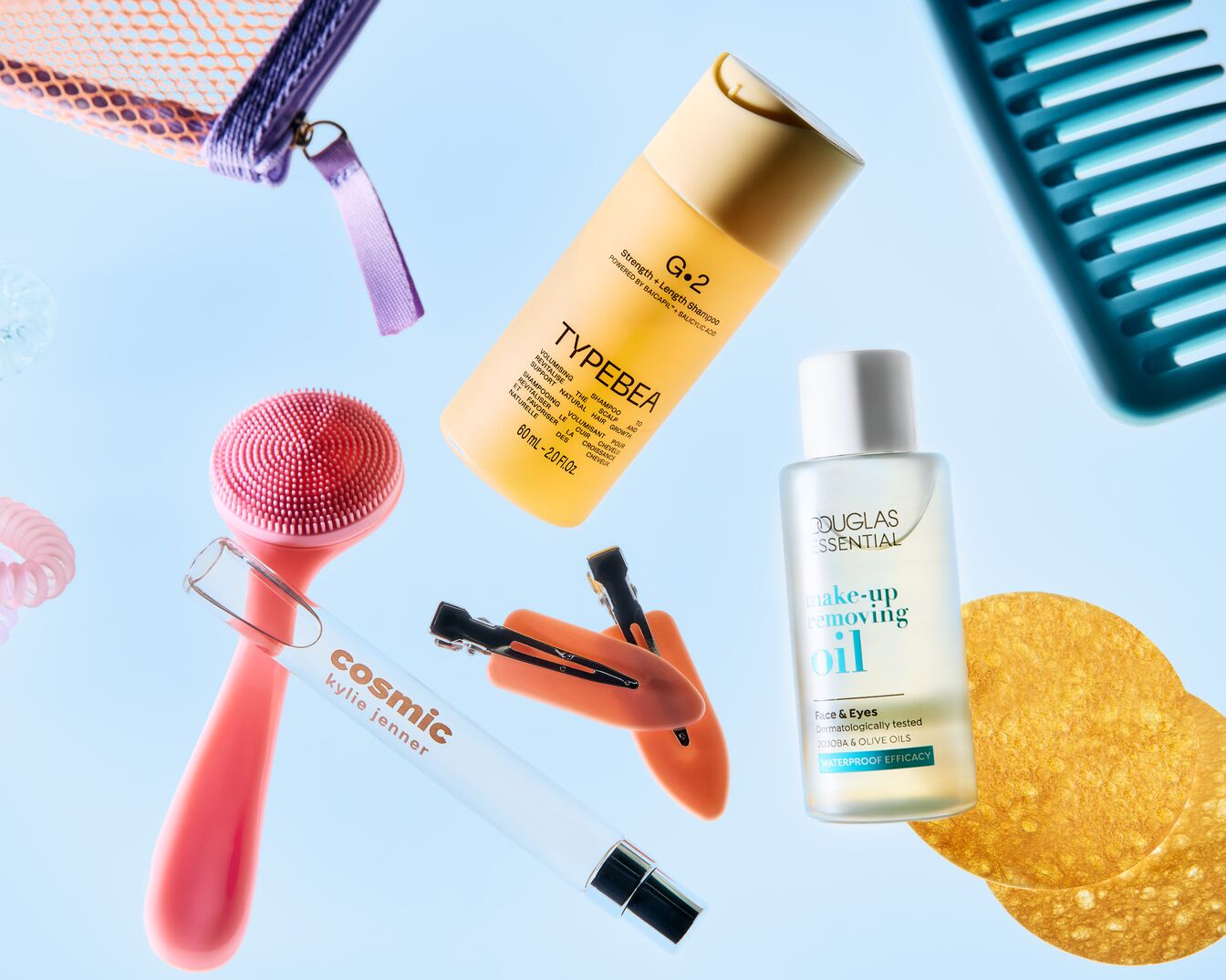 Een assortiment schoonheidsproducten, waaronder Typebea shampoo, Douglas make-up remover olie, een roze gezichtsborstel en Kylie Jenner cosmic.