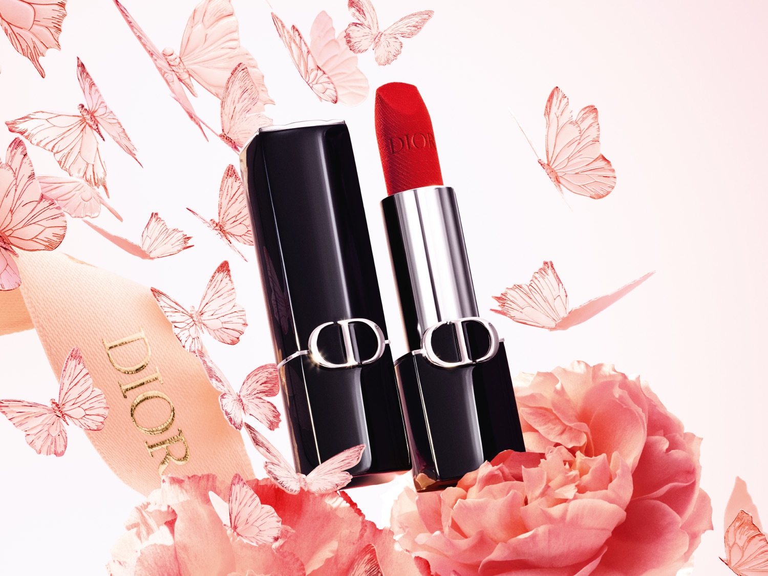 Een rode Dior-lippenstift met een zwarte huls staat open tussen roze bloemen en vlinders.