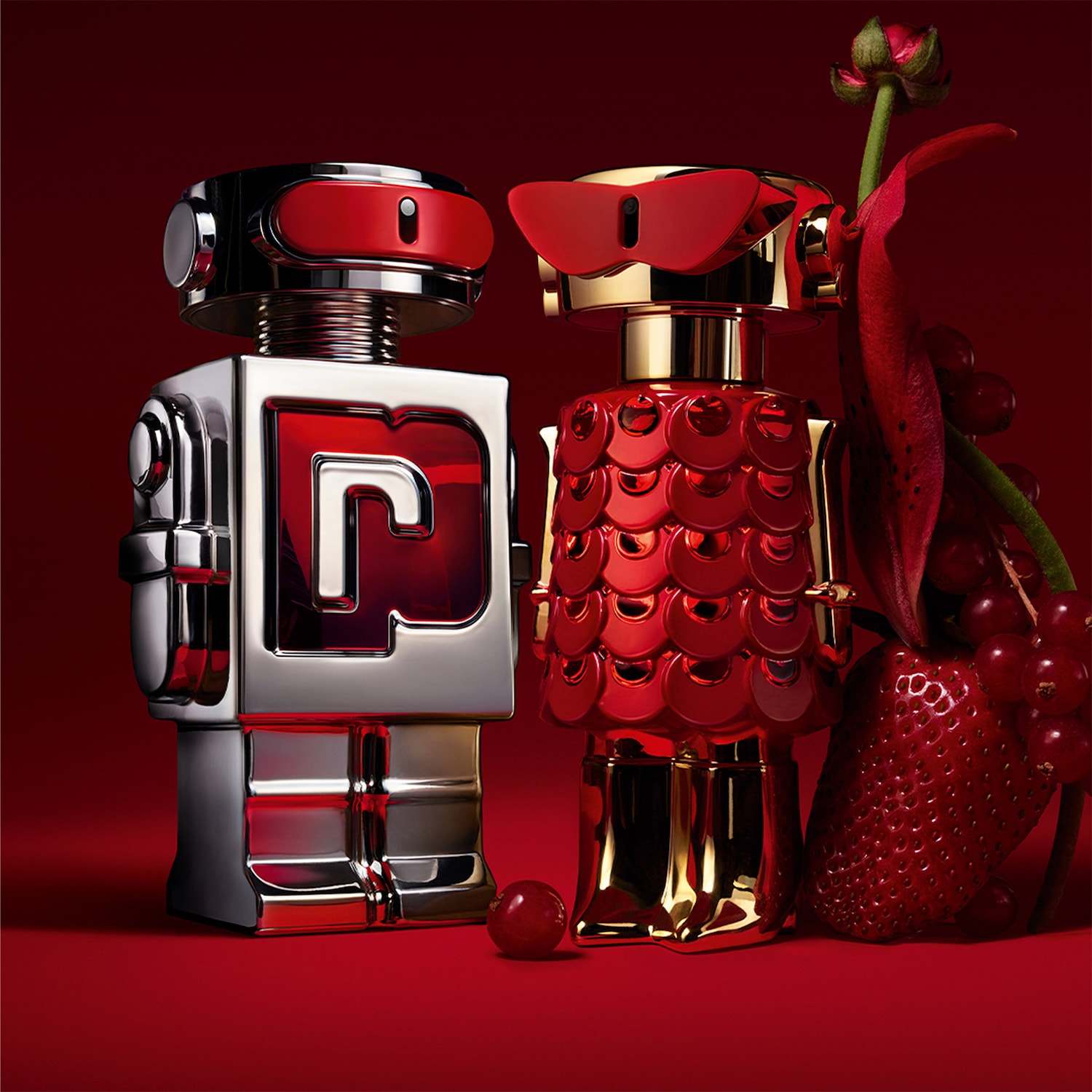 Découvrez le parfum Paco Rabanne Phantom, un duo futuriste de robots argenté et doré sur fond rouge, évoquant l'innovation et le luxe.