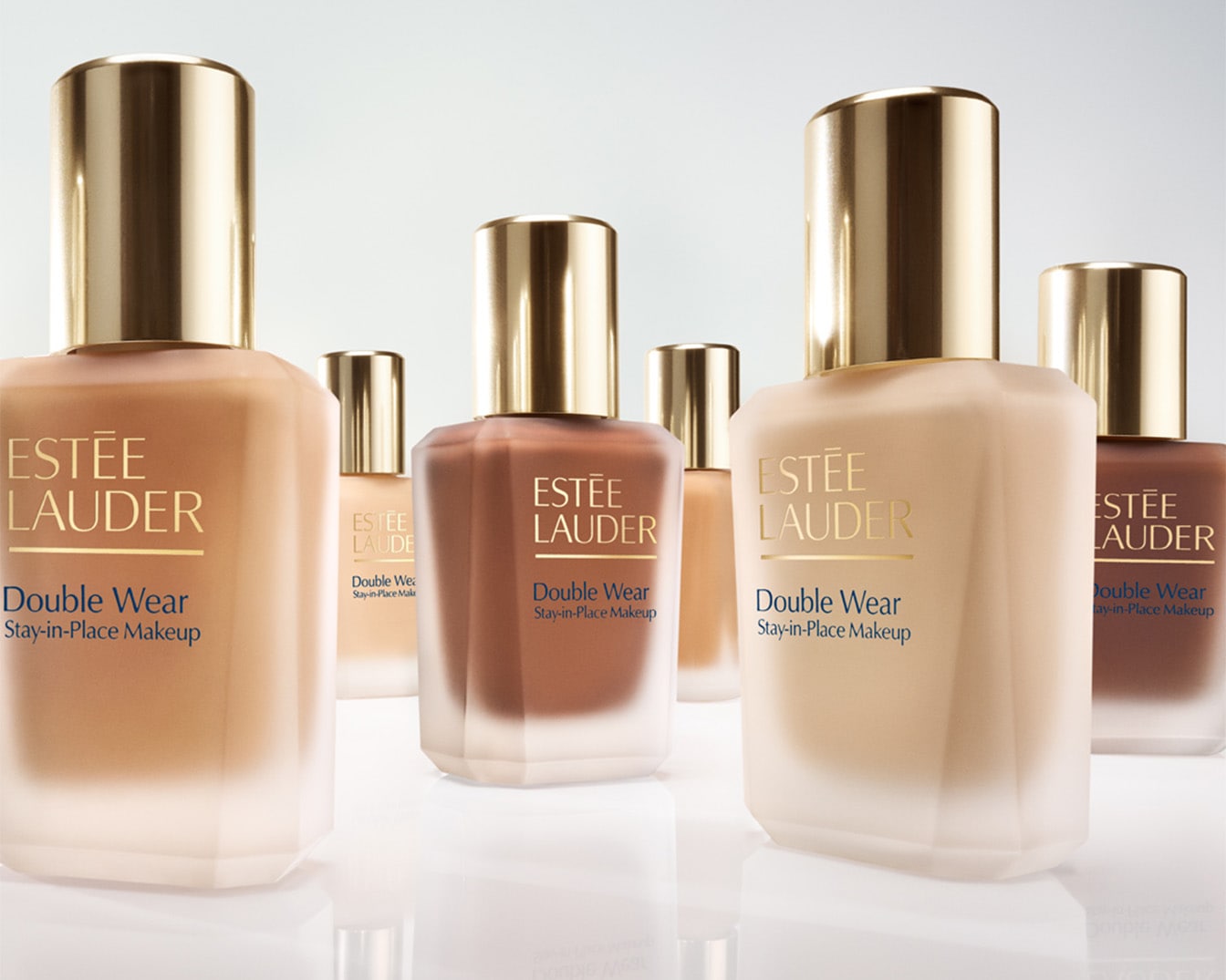 Ontdek Estée Lauder Double Wear Stay-in-Place Makeup, gepresenteerd in een reeks matte flessen met gouden accenten, die een reeks huidtinten beloven.