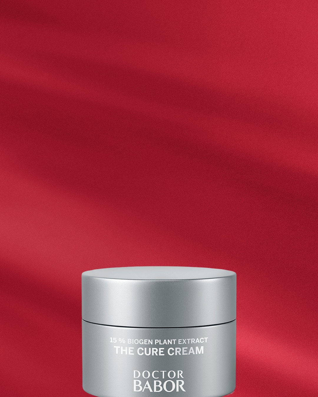 Srebrny słoiczek kremu Doctor Babor The Cure Cream z 15% ekstraktem z roślin biogennych na czerwonym tle.