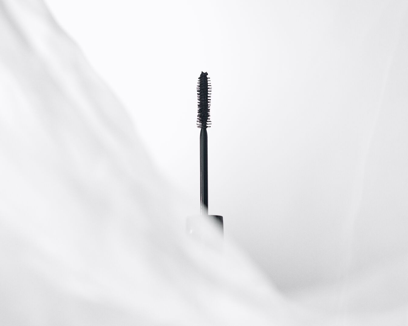 Nahaufnahme einer schwarzen Mascarabürste mit präzisen Borsten, die für Definition und Volumen der Wimpern sorgt.