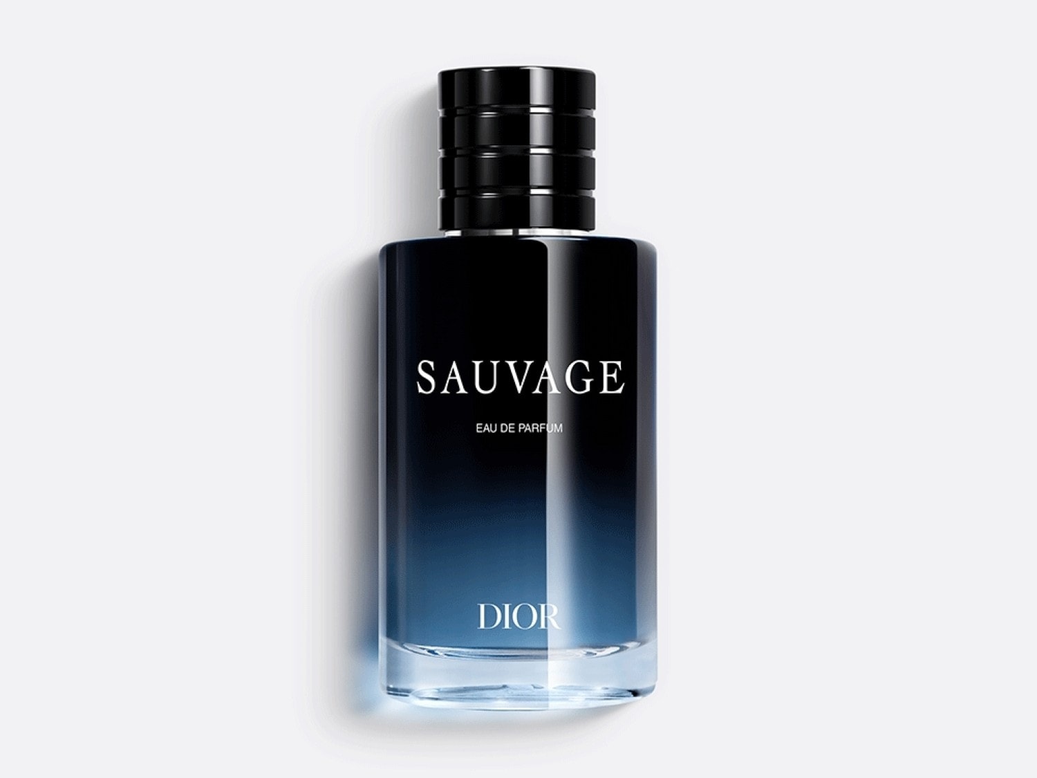 Le parfum Sauvage de Dior dans un flacon en verre dégradé bleu nuit, coiffé d'un bouchon noir cylindrique.