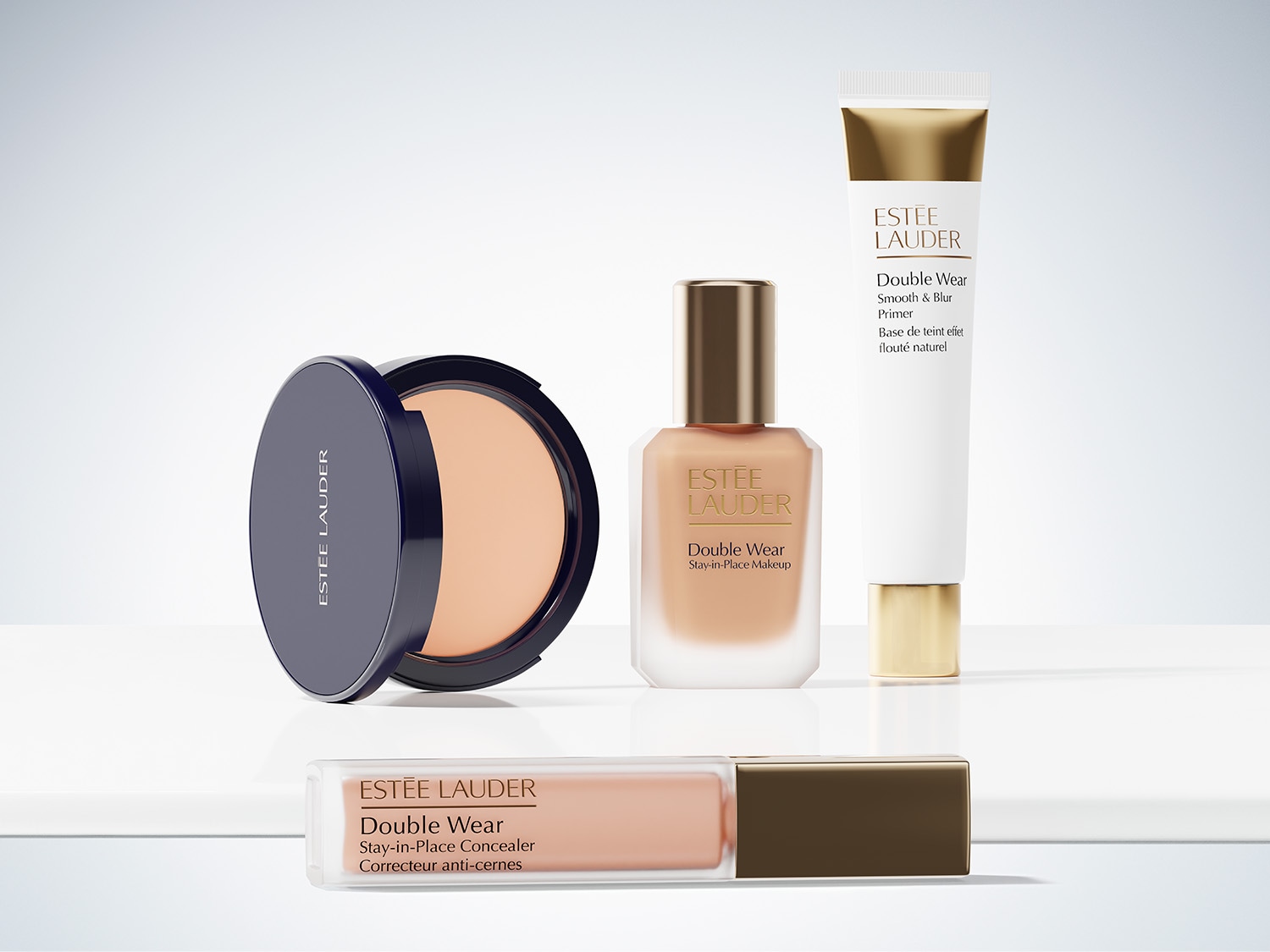 Mehrere Produkte der Linie Double Wear von Estée Lauder sind vor und auf einem weißen Podest angeordnet: Puder in schwarzer Dose, Foundation in einem Glasflakon, Concealer in einer transparenten Flasche und Primer in einer weißen Tube mit goldenen Akzenten.