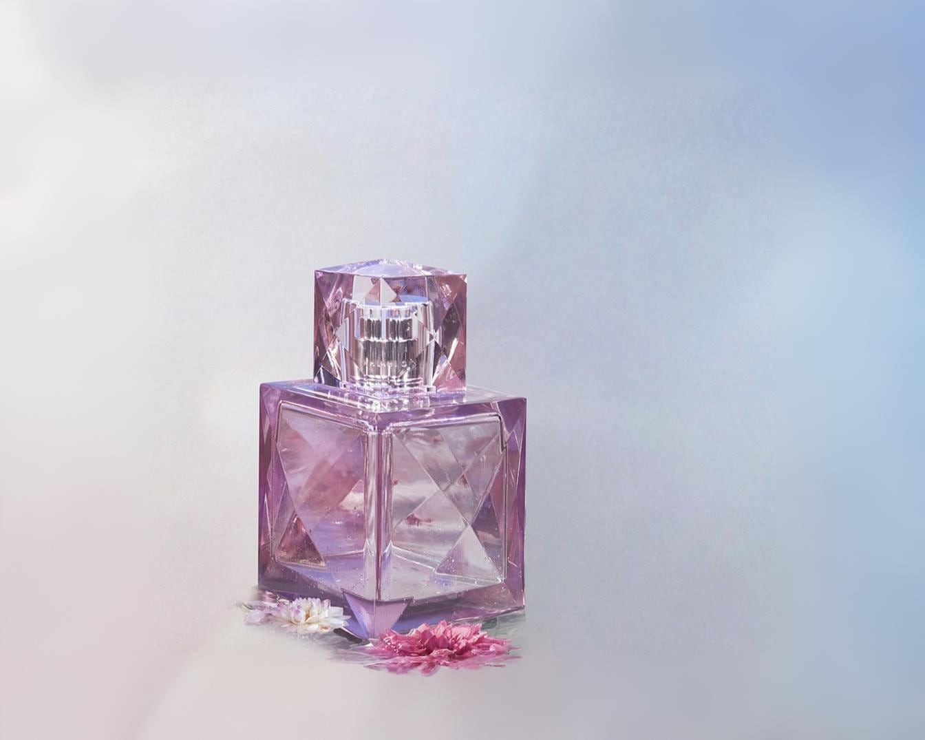 Kvepalų buteliukas yra kvadratinis, pagamintas iš skaidraus violetinio stiklo, su briaunotu kamšteliu ir papuoštas mažomis rožinėmis gėlėmis prie pagrindo.