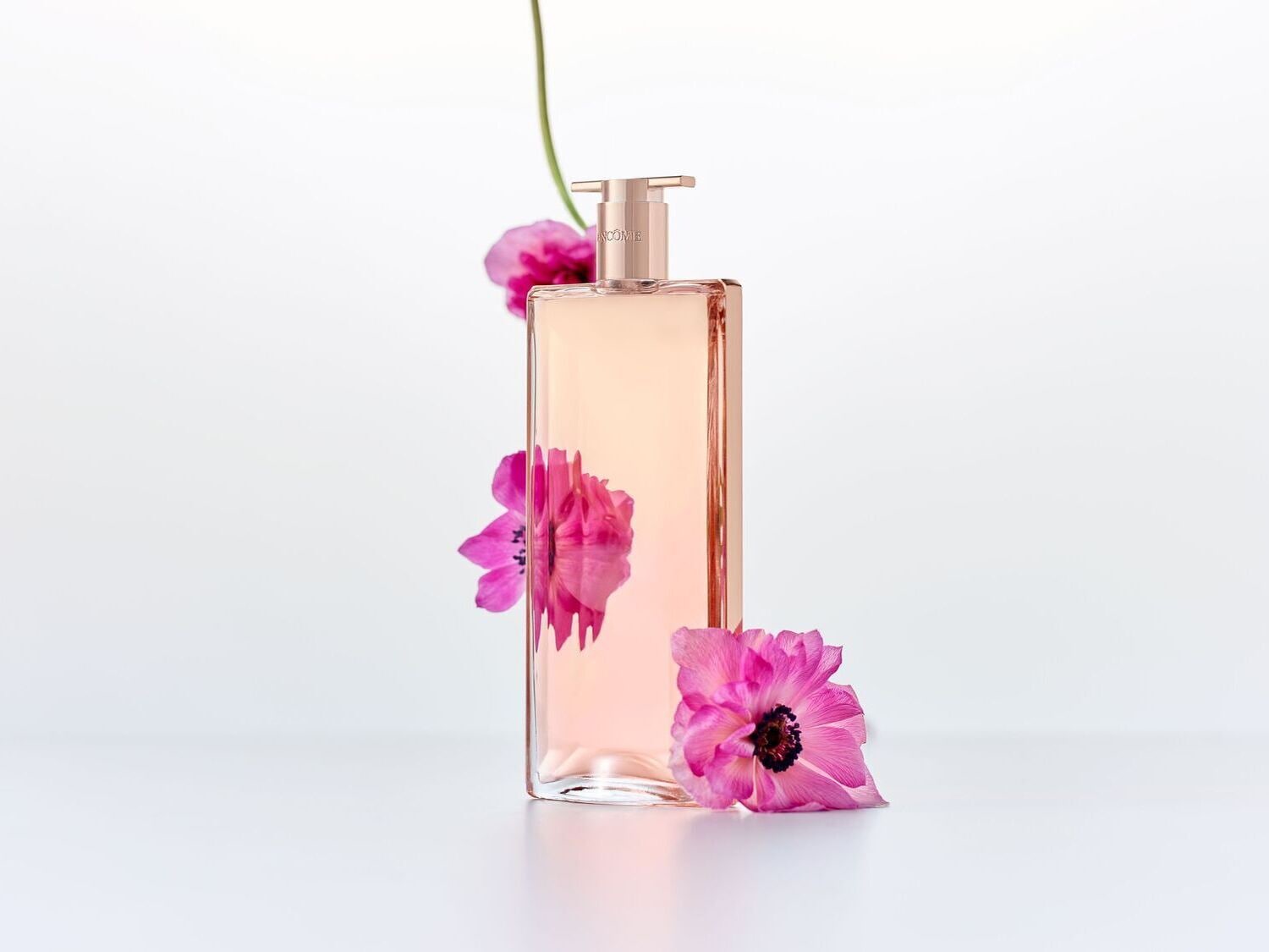 Stačiakampio formos „Lancôme Idôle“ kvepalų buteliukas, apsuptas ryškiai rožinių žiedų, sukuria gaivų ir moterišką įvaizdį.