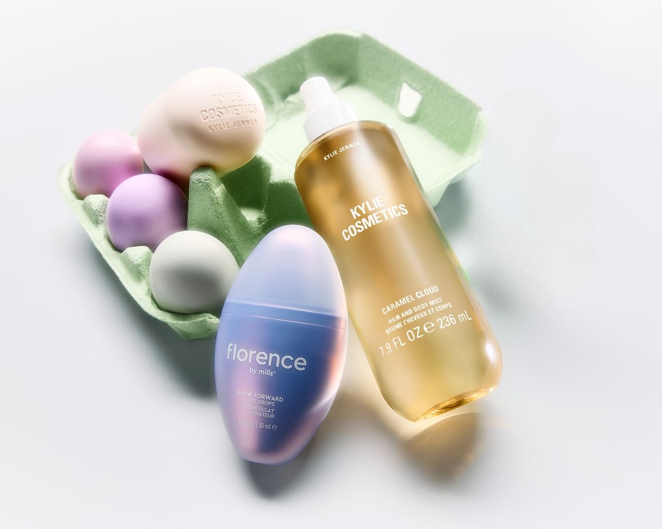 Kiaušinių dėžutėje matomi „Kylie Cosmetics“ ir „Florence by Mills“ kosmetikos gaminiai, įskaitant „Caramel Cloud“ purškiklį plaukams ir kūnui.