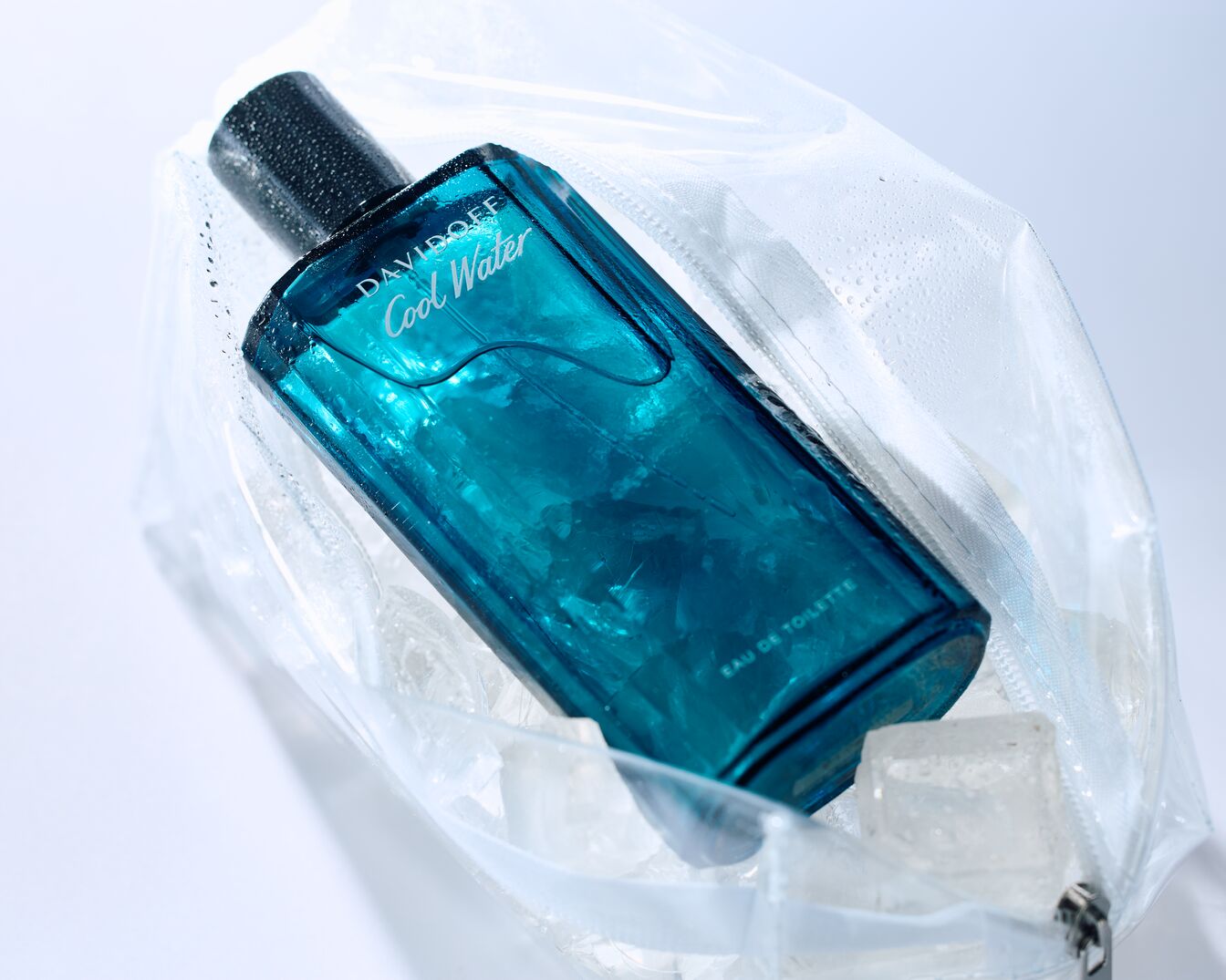Le parfum Davidoff Cool Water dans son emballage transparent, évoquant la fraîcheur avec des gouttes d'eau et des glaçons.