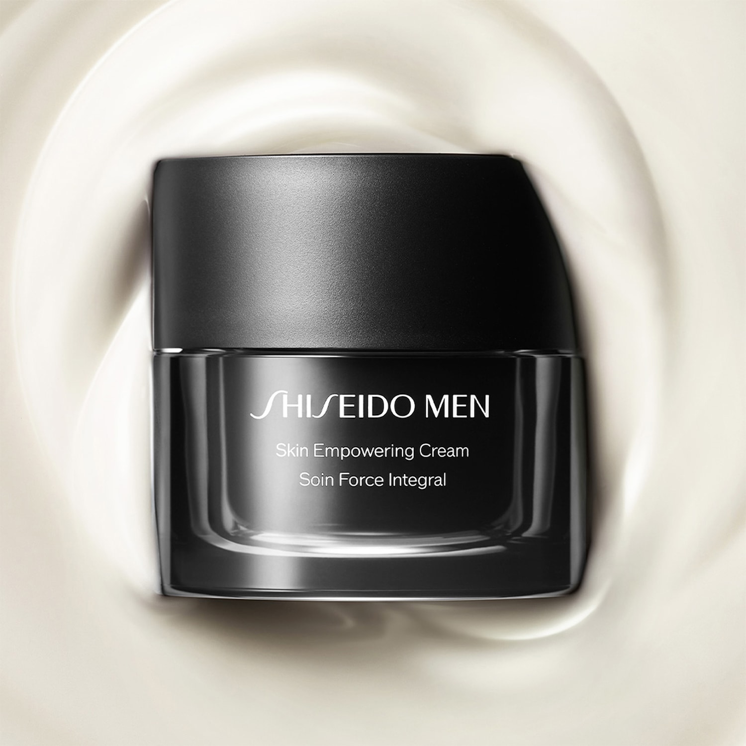 Nahaufnahme des schwarzen Tiegels der Shiseido Men Skin Empowering Cream, umgeben von der cremefarbenen Textur der Cream.