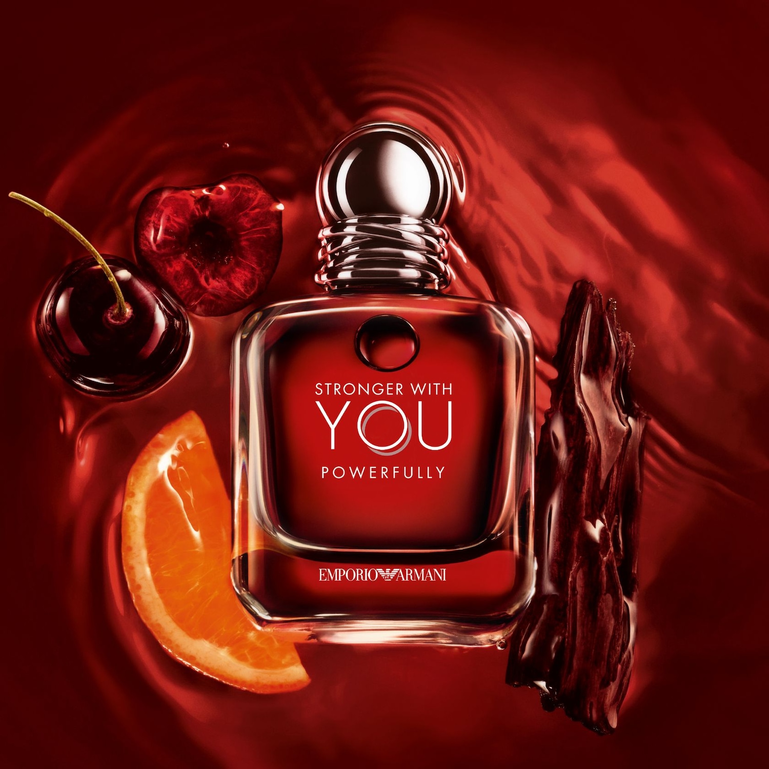 Čtvercový flakon parfému Emporio Armani Stronger With You Powerfully v červených tónech s třešněmi, pomerančem a kouskem dřeva.