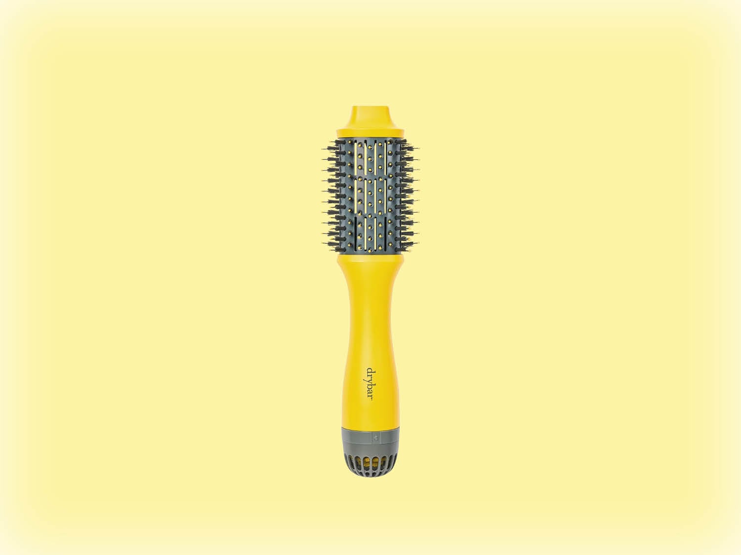 Voici une brosse à cheveux ronde jaune de Drybar, conçue pour coiffer et donner du volume aux cheveux.