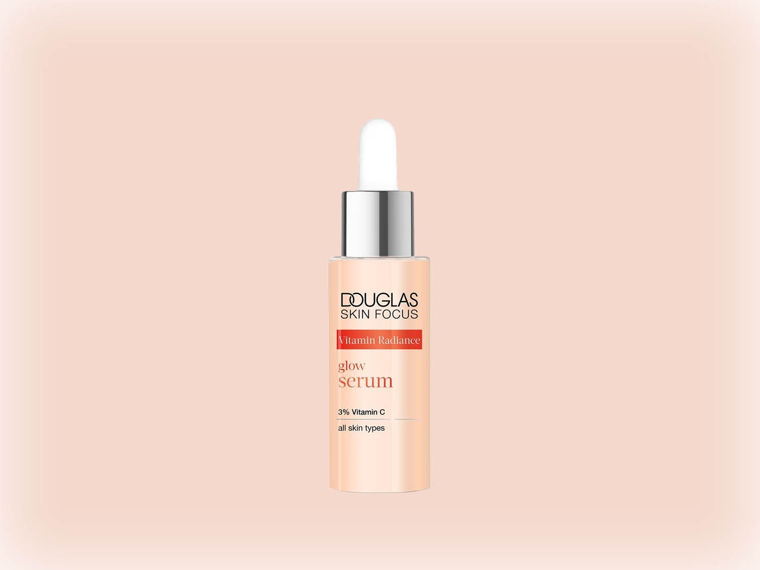 Découvrez le Sérum Éclat Vitamin Radiance de Douglas Skin Focus, un soin pour tous types de peau enrichi à 3% de vitamine C, présenté dans un flacon pêche avec pipette argentée.