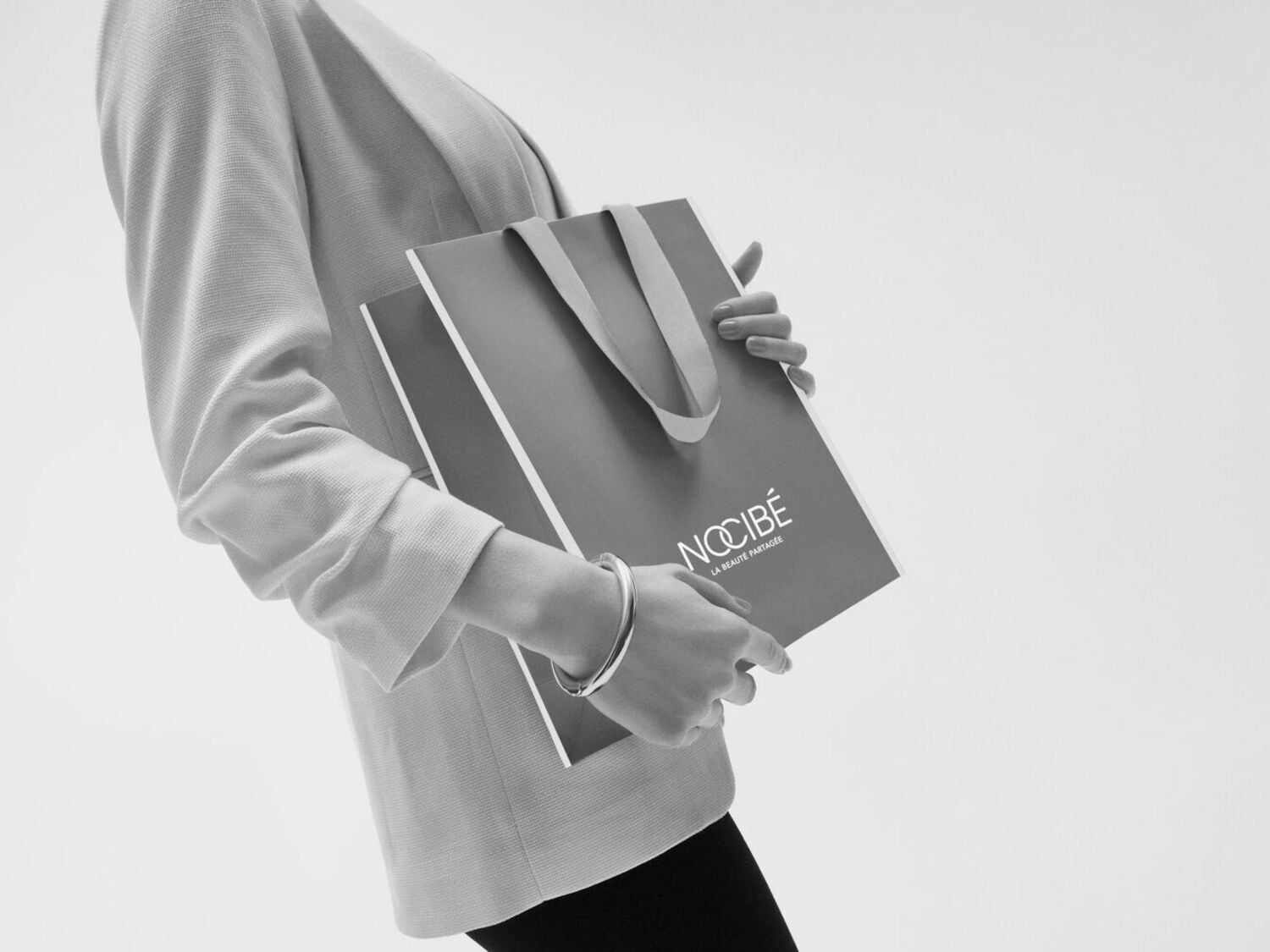 Une personne tenant un sac Nocibé, symbole de beauté partagée et d'élégance.