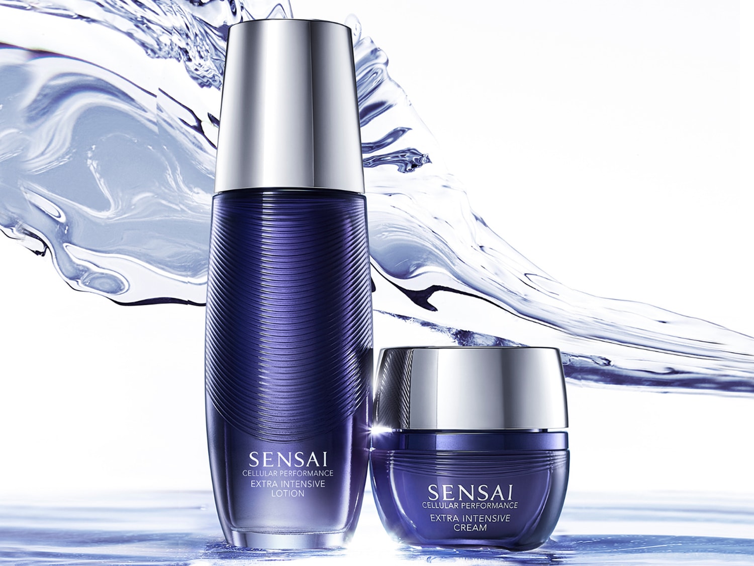 Súprava Sensai Cellular Performance Extra Intensive Lotion a krém v modrom balení so strieborným vrchnákom, obklopená striekajúcou vodou.