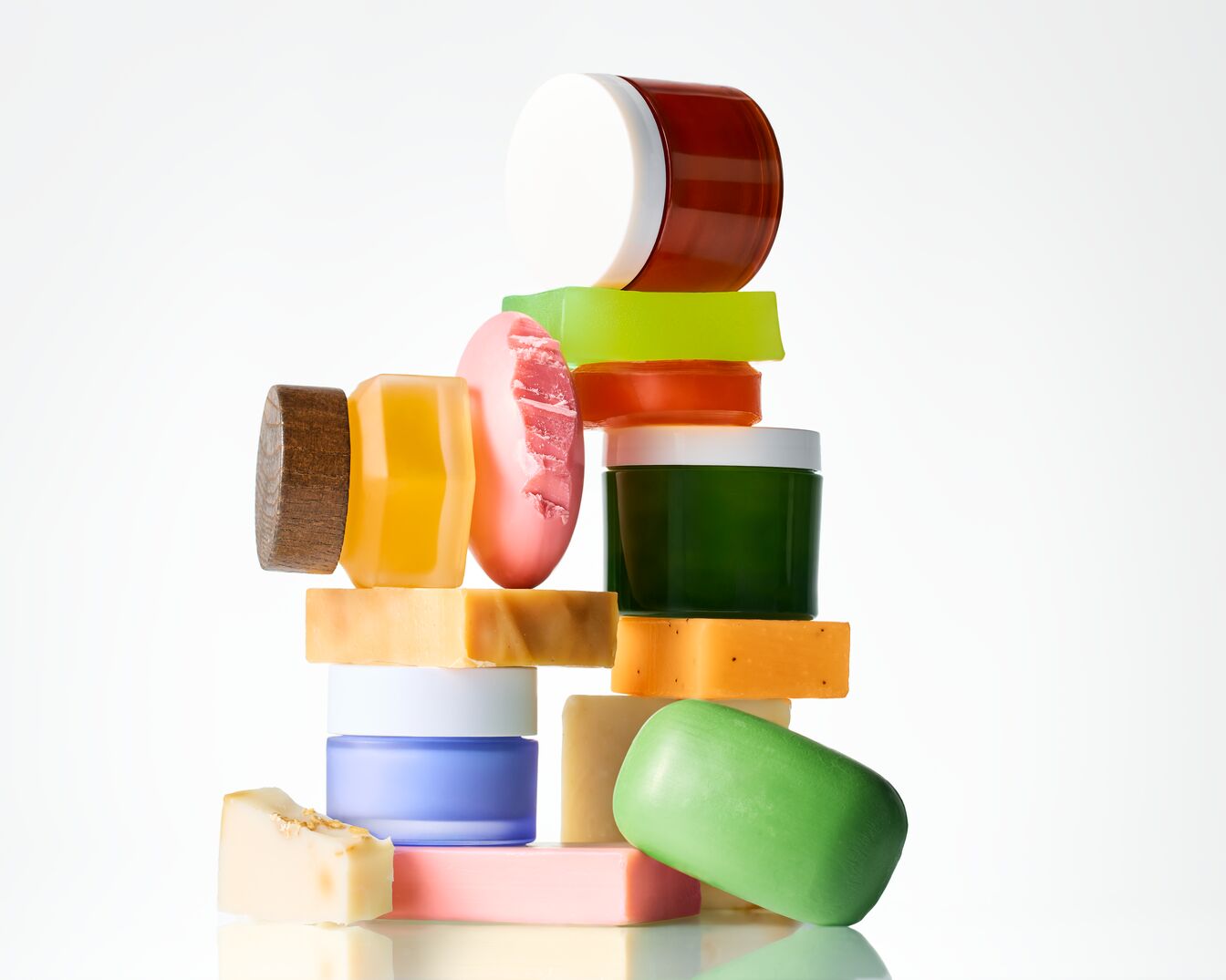 Une pile de savons colorés et de pots de crème, offrant une variété de soins pour la peau.