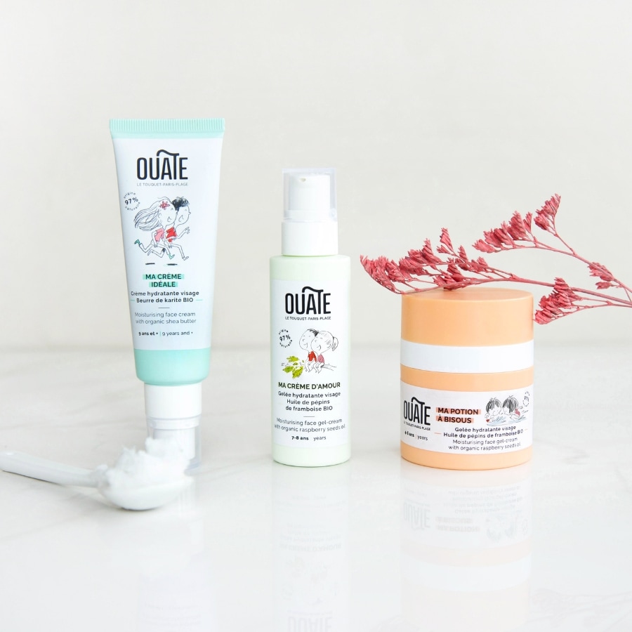 Produits de soin disposés sur une surface claire, flacons et tubes de soins pour enfants.