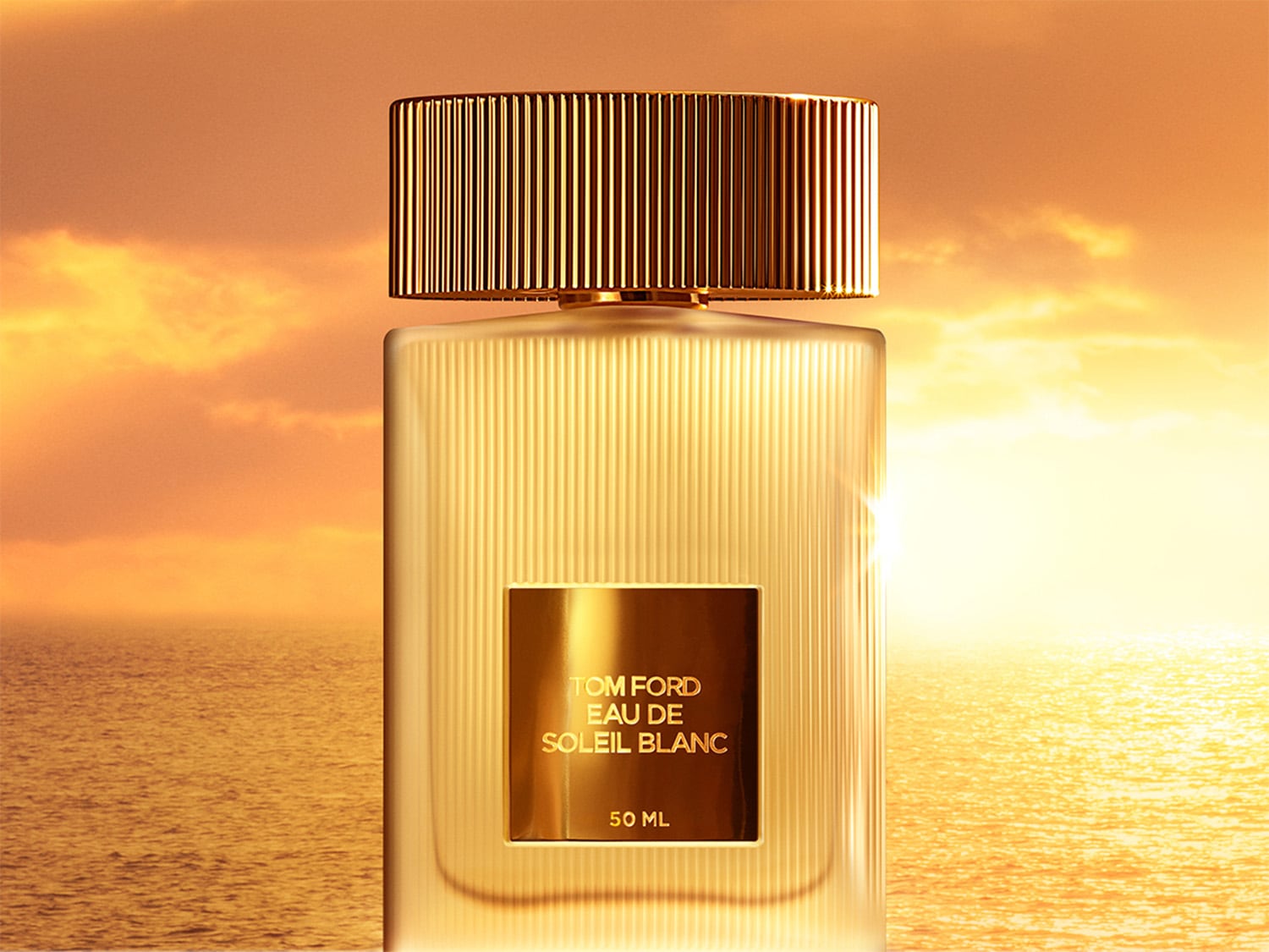 Le parfum Tom Ford Eau de Soleil Blanc dans un flacon transparent avec un bouchon doré, évoquant l'éclat du soleil sur la mer.
