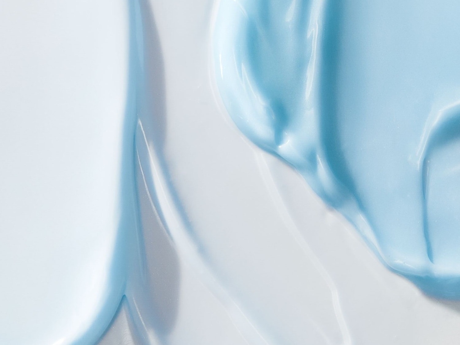 Primo piano di una crema liscia e idratante di colore azzurro chiaro, ideale per nutrire e proteggere la pelle.