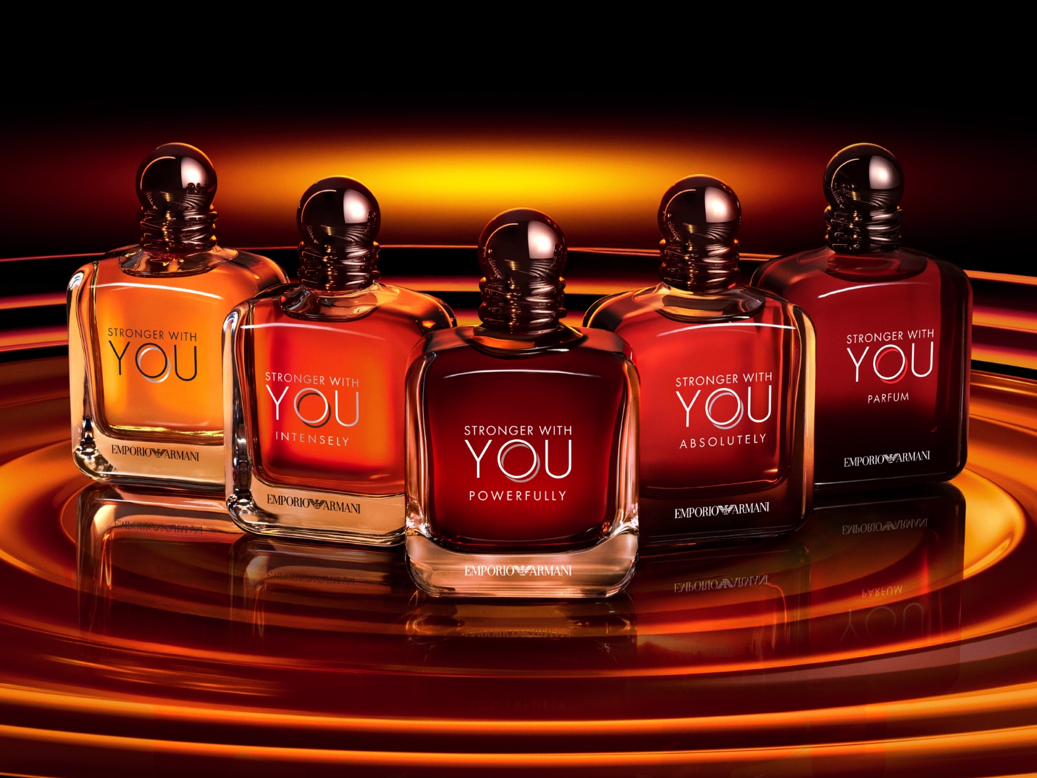 Pět flakonů parfému Emporio Armani Stronger With You v odstínech od světle oranžové po tmavě červenou, které odrážejí intenzitu vůně.