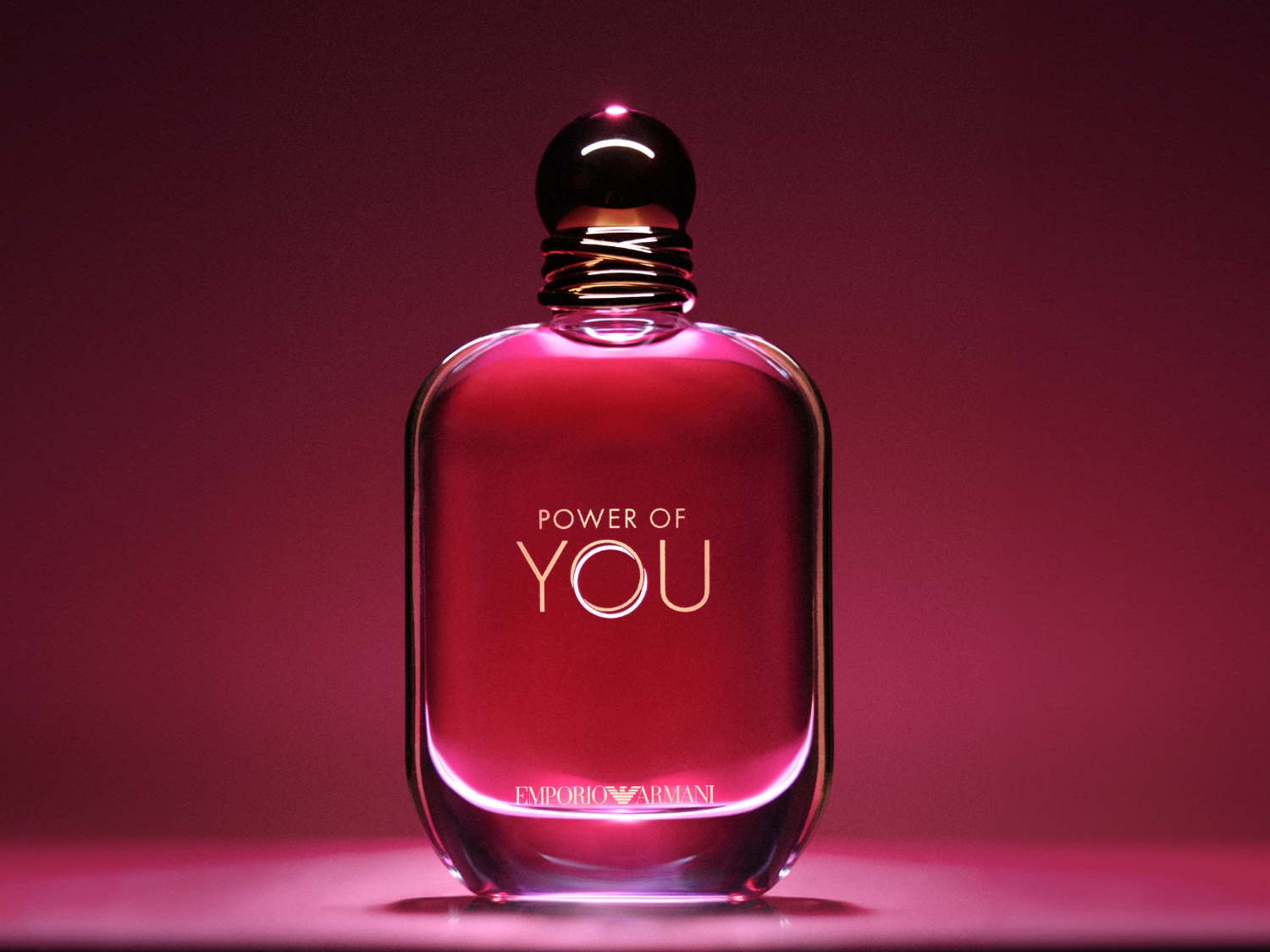 Flakón dámskeho parfumu Emporio Armani Power of You má ružovkastú farbu a okrúhly čierny vrchnák.