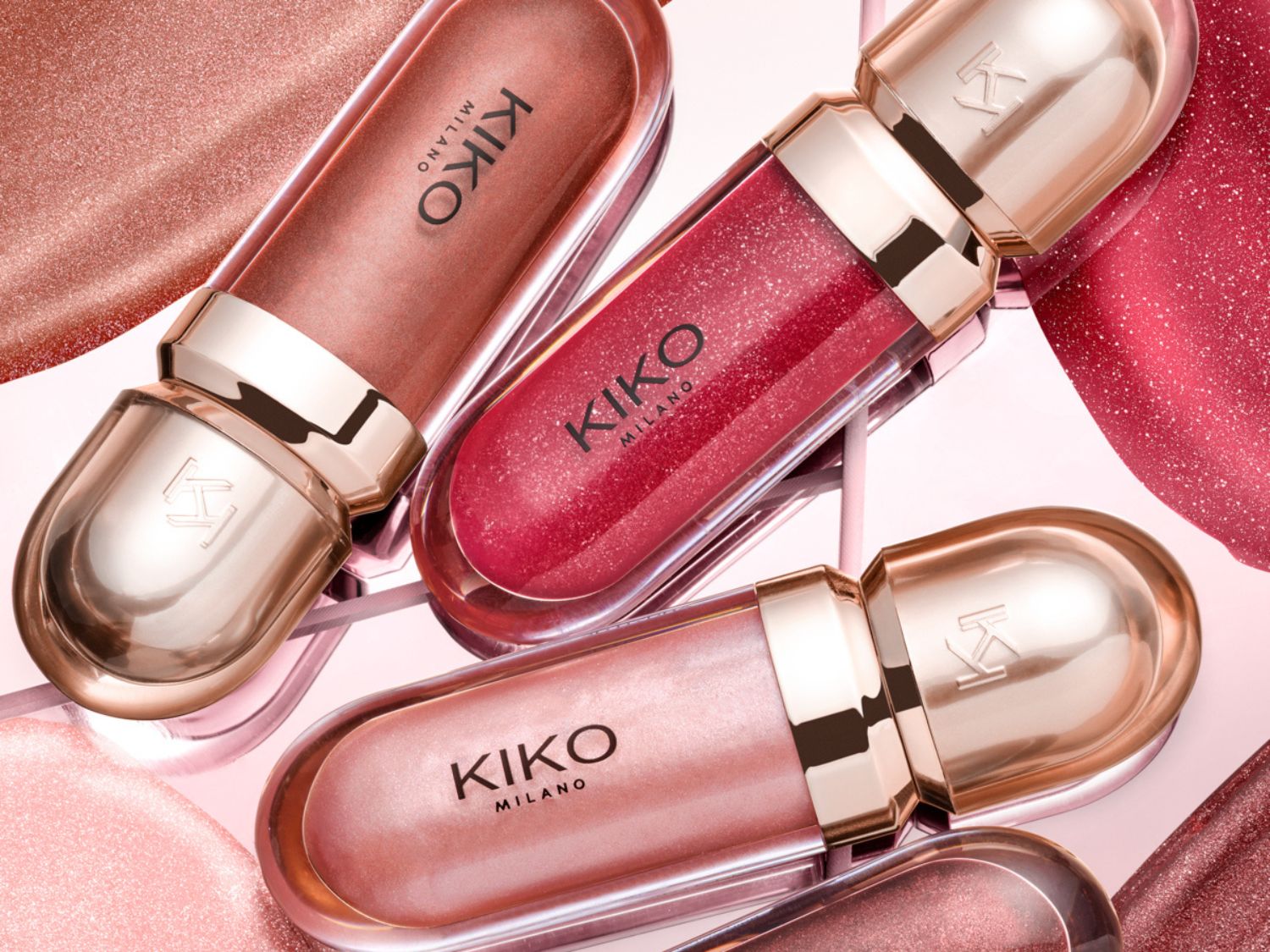 Nahaufnahme von Kiko Milano Lipgloss in verschiedenen Farbtönen, von schimmerndem Rosa bis hin zu tiefem Rot, präsentiert in eleganten, goldenen Verpackungen.