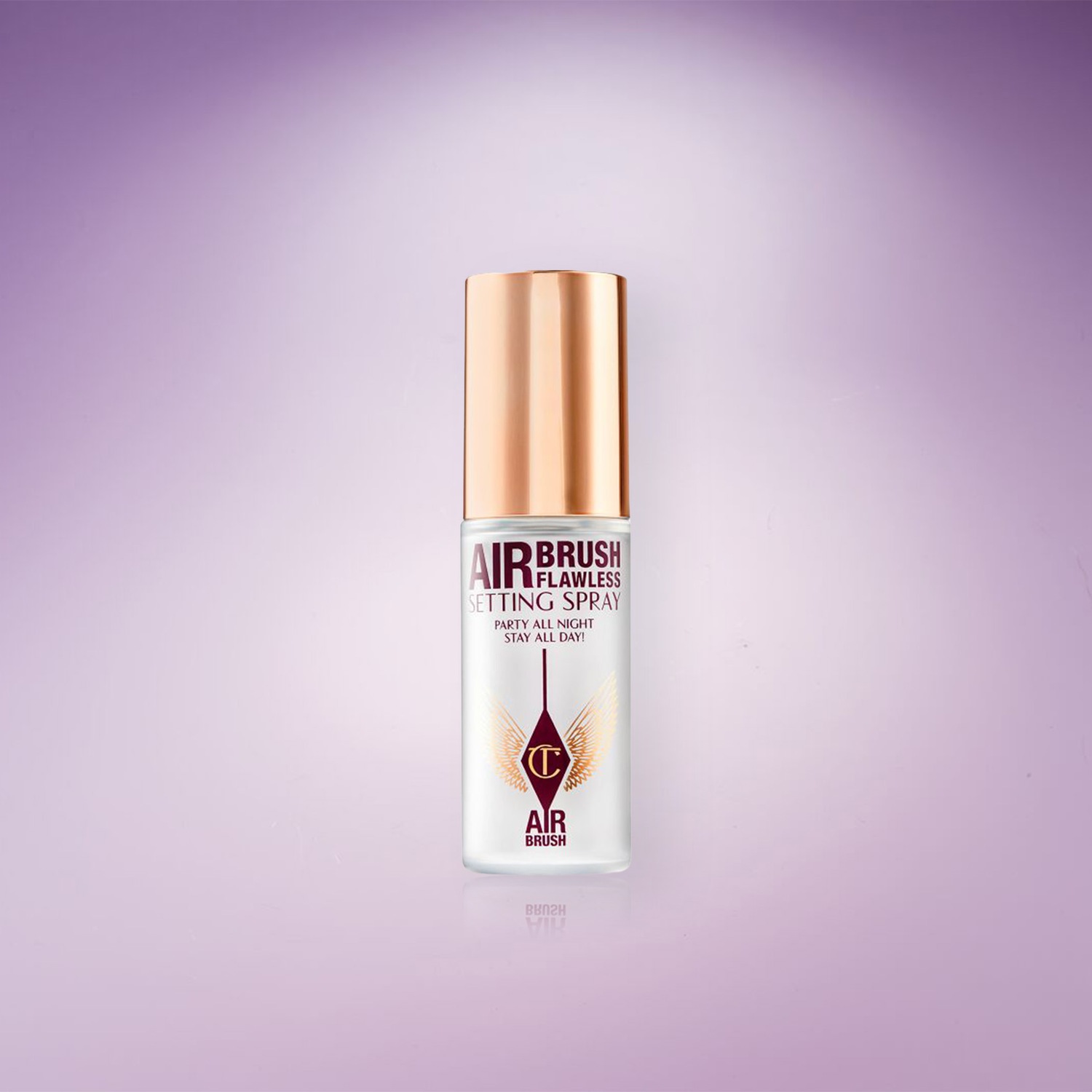 Voici un spray fixateur Airbrush Flawless de Charlotte Tilbury, avec un bouchon doré et un flacon transparent portant l'inscription "Party all night! Stay all day!".