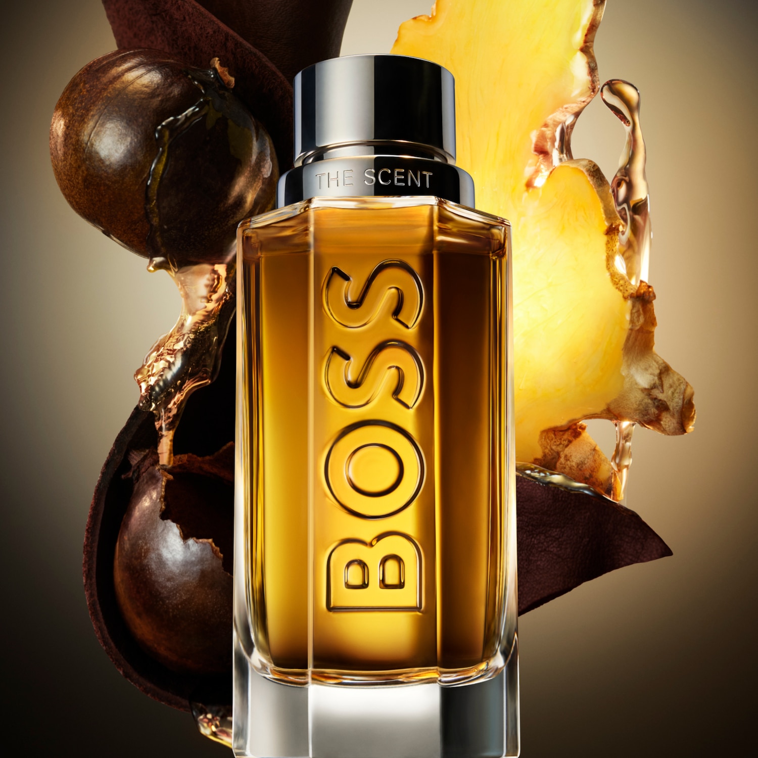 Butelka perfum BOSS The Scent o bursztynowym odcieniu, z nutami imbiru i owoców maninka, otoczona skórą i kroplami esencji.