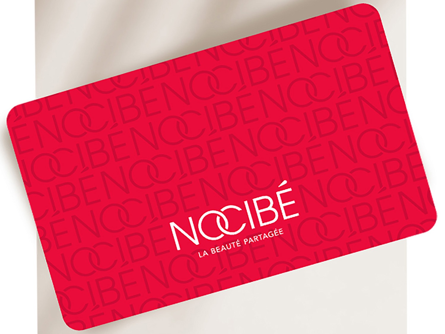 Voici une carte cadeau Nocibé rouge, ornée du logo Nocibé en blanc, idéale pour offrir un moment de beauté.