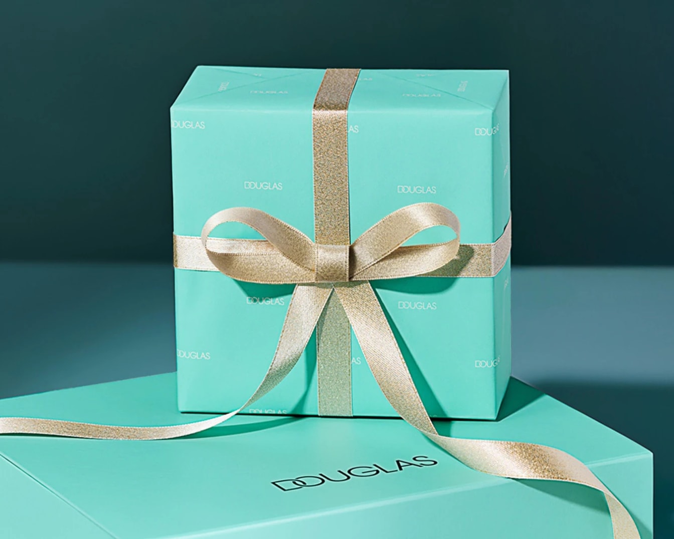 Błękitne pudełko prezentowe Douglas przewiązane złotą wstążką, idealne na każdą okazję.
