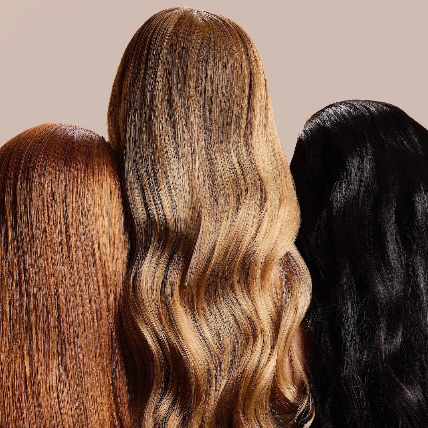 Gros plan sur trois chevelures lisses et brillantes : une rousse, une blonde ondulée et une noire.