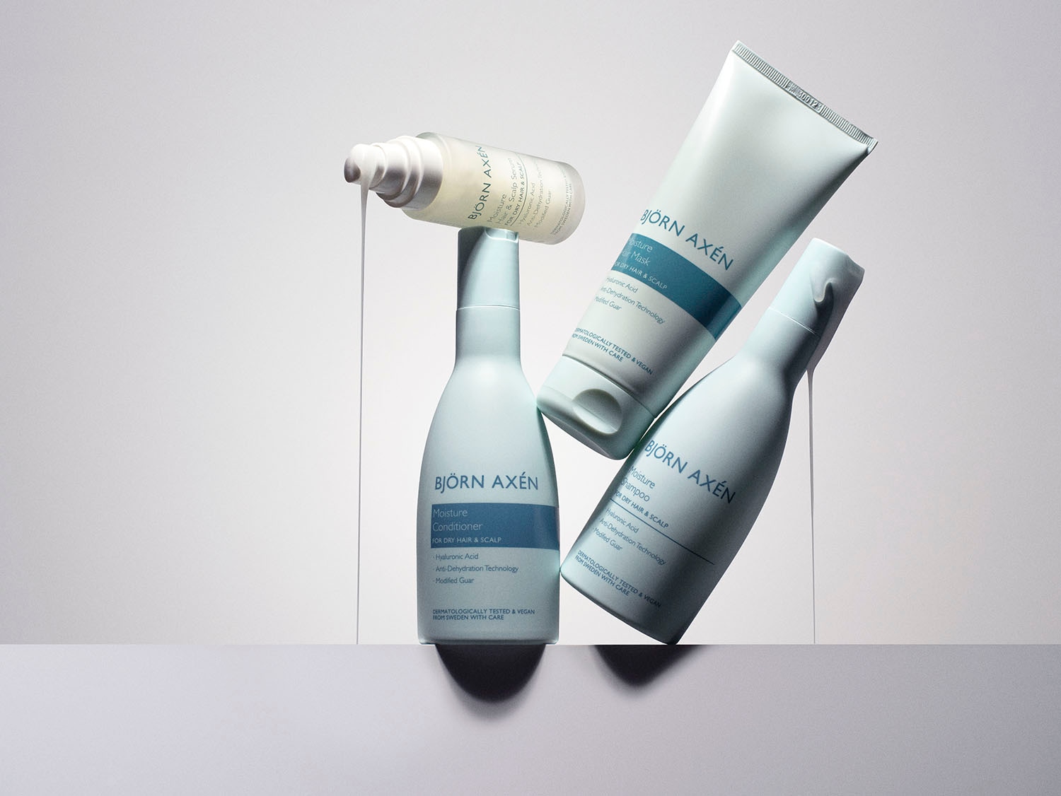 Kolekcja Björn Axén Moisture do włosów suchych i skóry głowy: serum, odżywka, maska i szampon z kwasem hialuronowym, testowane dermatologicznie i wegańskie.