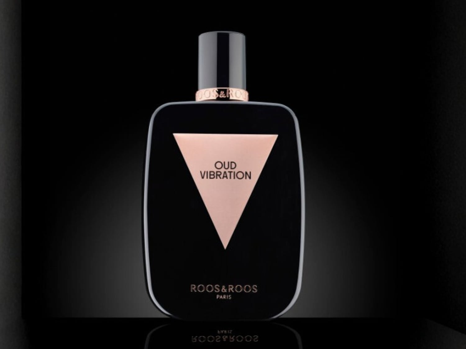 Découvrez Oud Vibration de Roos&Roos Paris, un parfum dans un flacon noir élégant avec un triangle rose portant le nom du parfum.