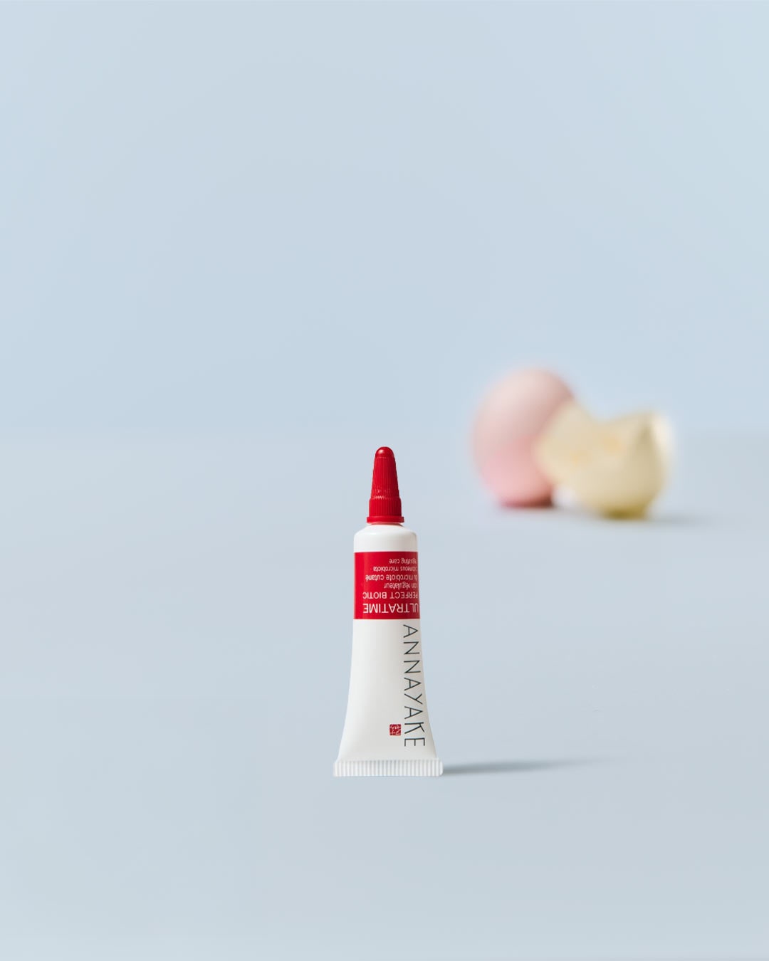 Nahaufnahme einer weißen Tube Annayake Ultratime Perfect Biotic mit roter Kappe, die eine revitalisierende und schützende Hautpflege verspricht.