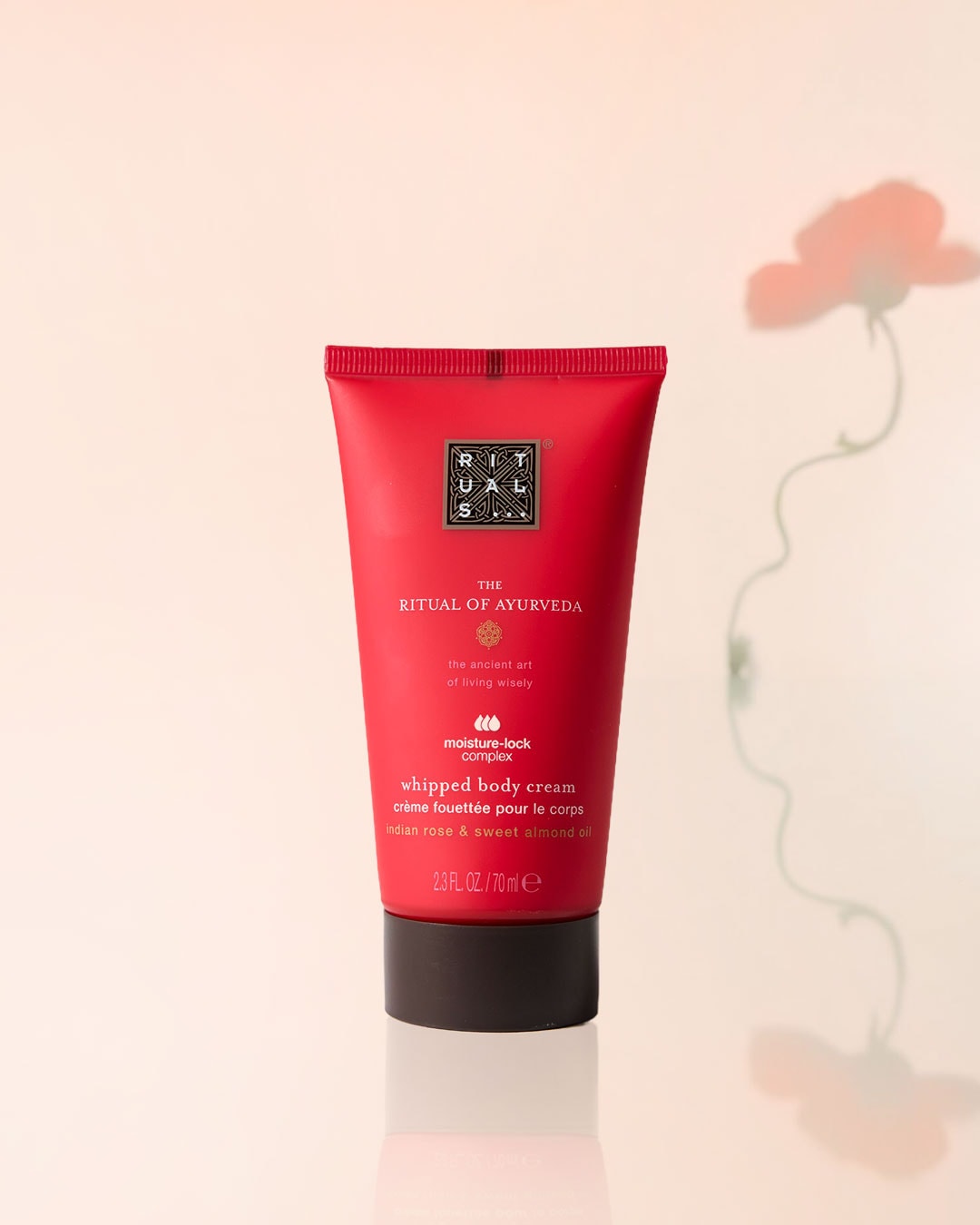Die Ritual of Ayurveda Whipped Body Cream in einer roten Tube mit dunklem Verschluss, angereichert mit indischer Rose und Süßmandelöl für eine Feuchtigkeitspflege.