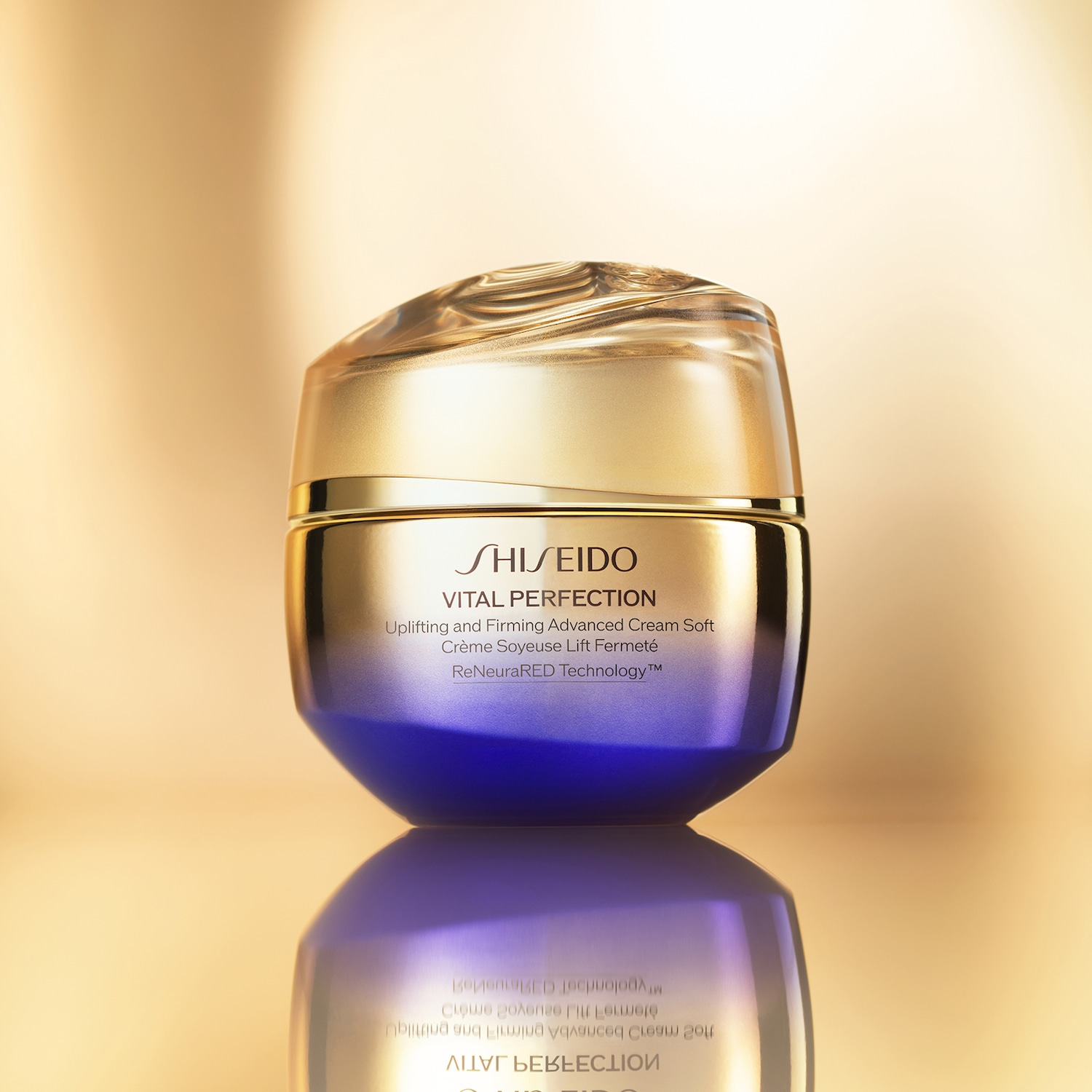 Ecco Shiseido Vital Perfection, una crema morbida avanzata che solleva e rassoda, in un barattolo dorato con base blu sfumata.