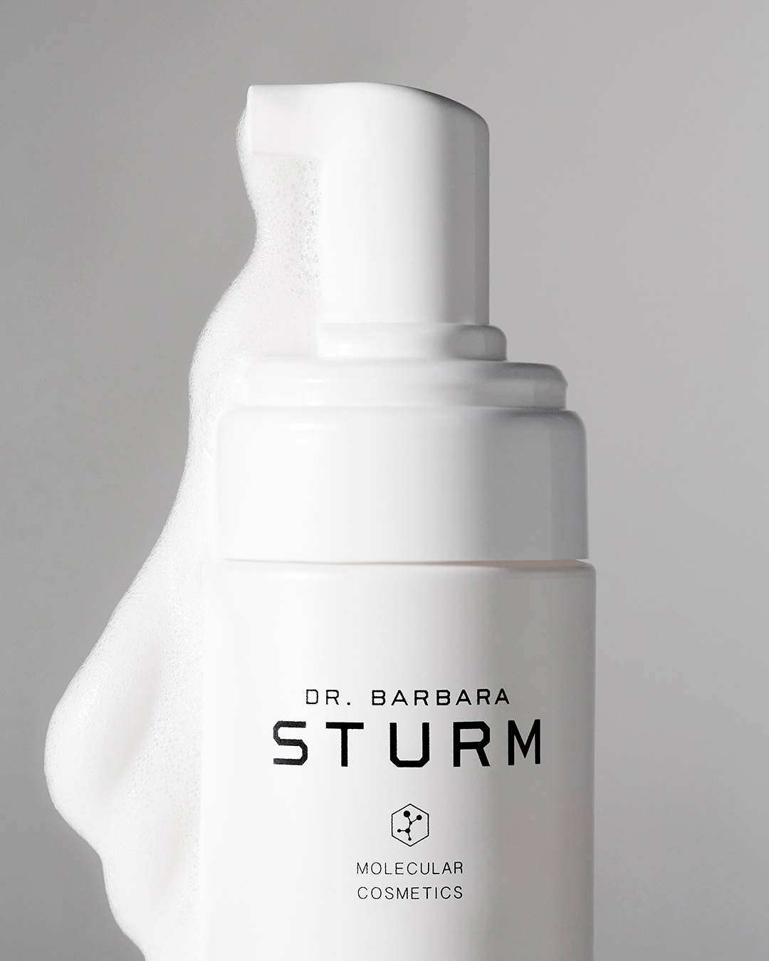 Nahaufnahme der weißen Verpackung des Molecular Cosmetics Reinigungsschaums von von Dr. Barbara Sturm, der einen Pumpspender und eine cremige Textur zeigt.