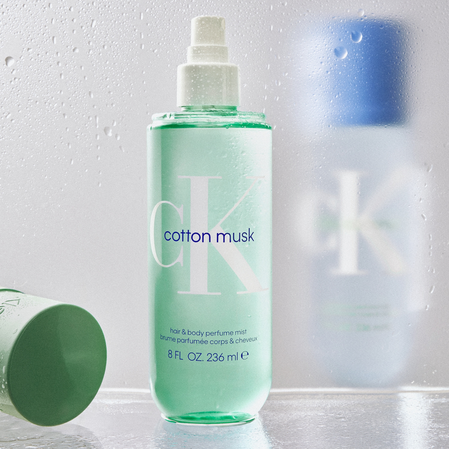 Błękitna butelka CK Cotton Musk hair & body perfume mist o pojemności 236 ml, idealna do odświeżenia włosów i ciała.