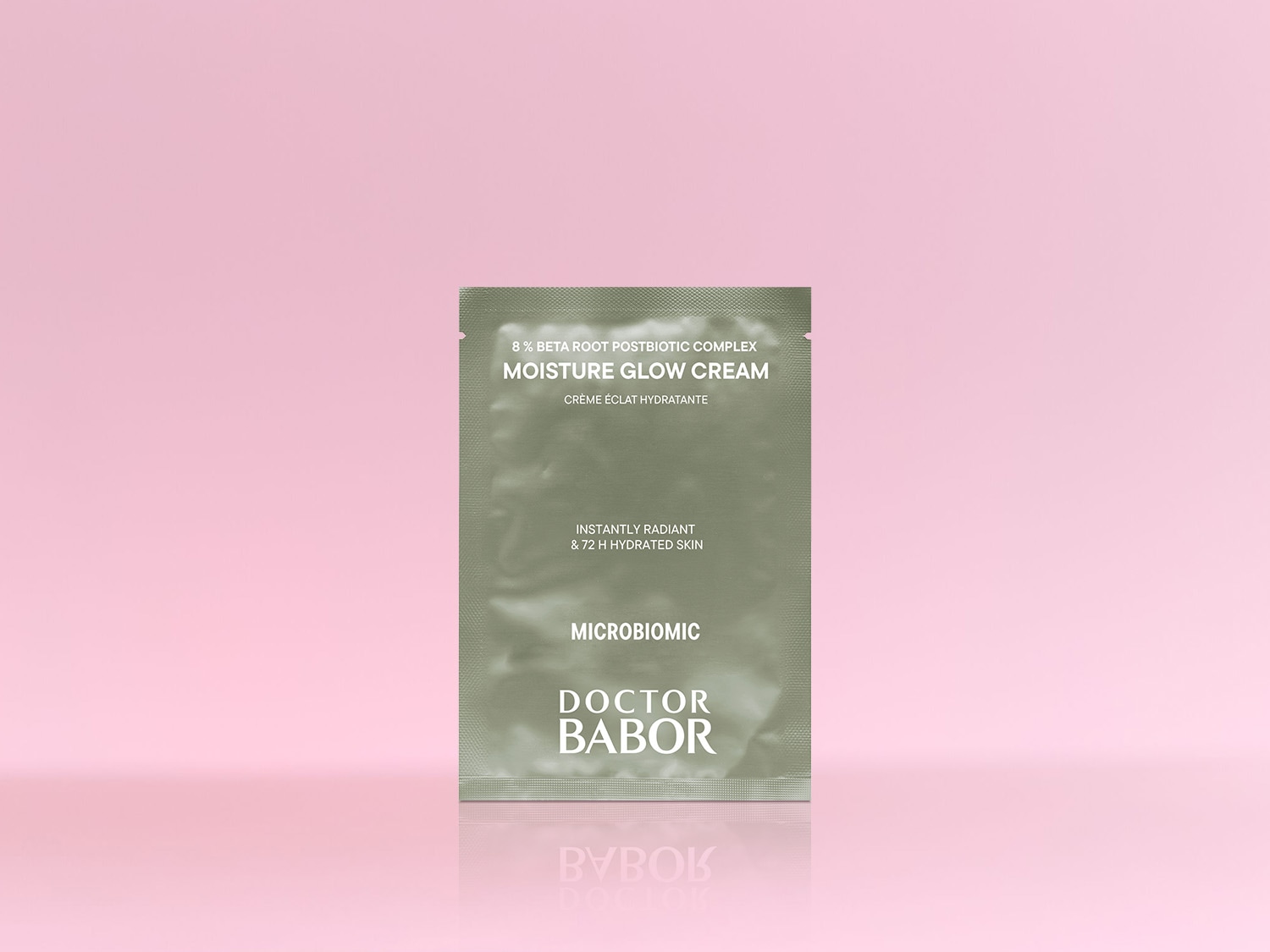 Die Doctor Babor Moisture Glow Cream mit 8% Beta Root Postbiotic Complex für sofortige Ausstrahlung und 72 Stunden hydratisierte Haut in einer olivgrünen Verpackung vor einem rosa Hintergrund.