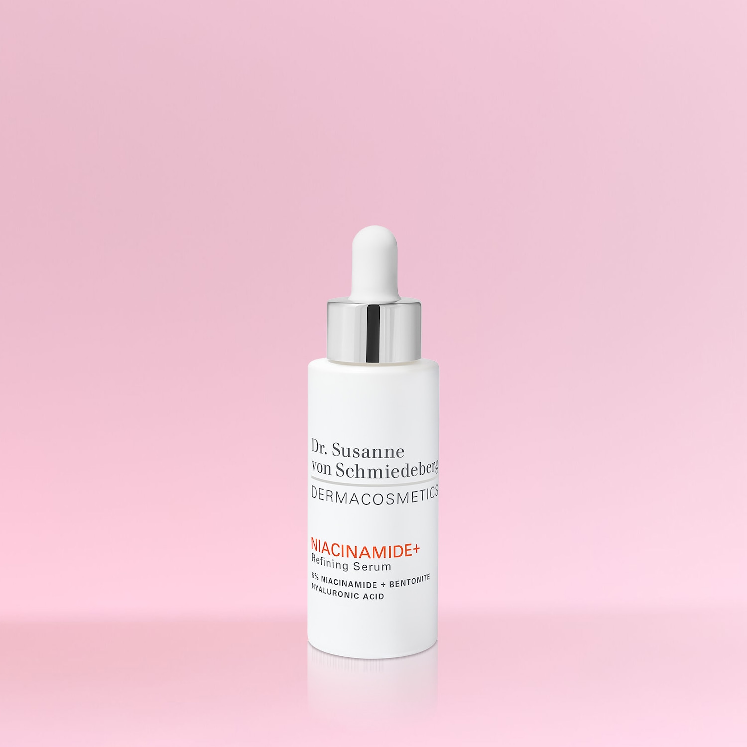Dr. Susanne von Schmiedeberg DERMACOSMETICS NIACINAMIDE+ Verfeinerungsserum mit 5% Niacinamid + Bentonit und Hyaluronsäure in einer weißen Flasche mit silbernem Deckel.