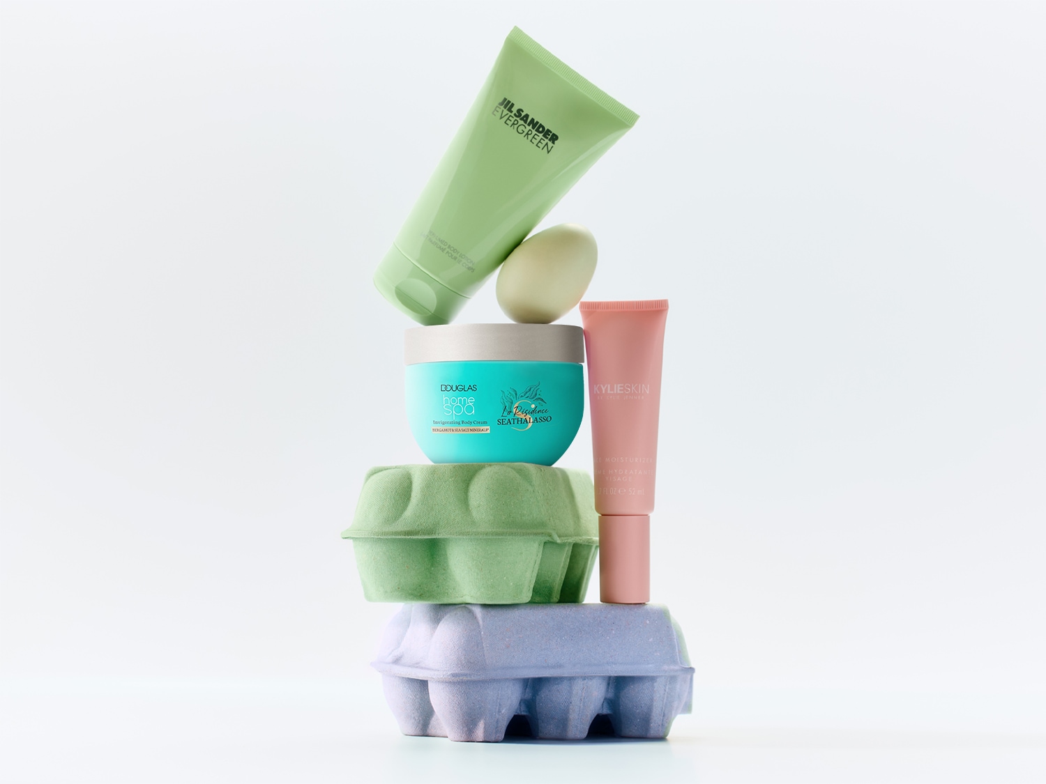 Découvrez une collection de soins corporels comprenant Jil Sander Evergreen, Douglas Home Spa et KylieSkin, présentés dans des emballages colorés et modernes.