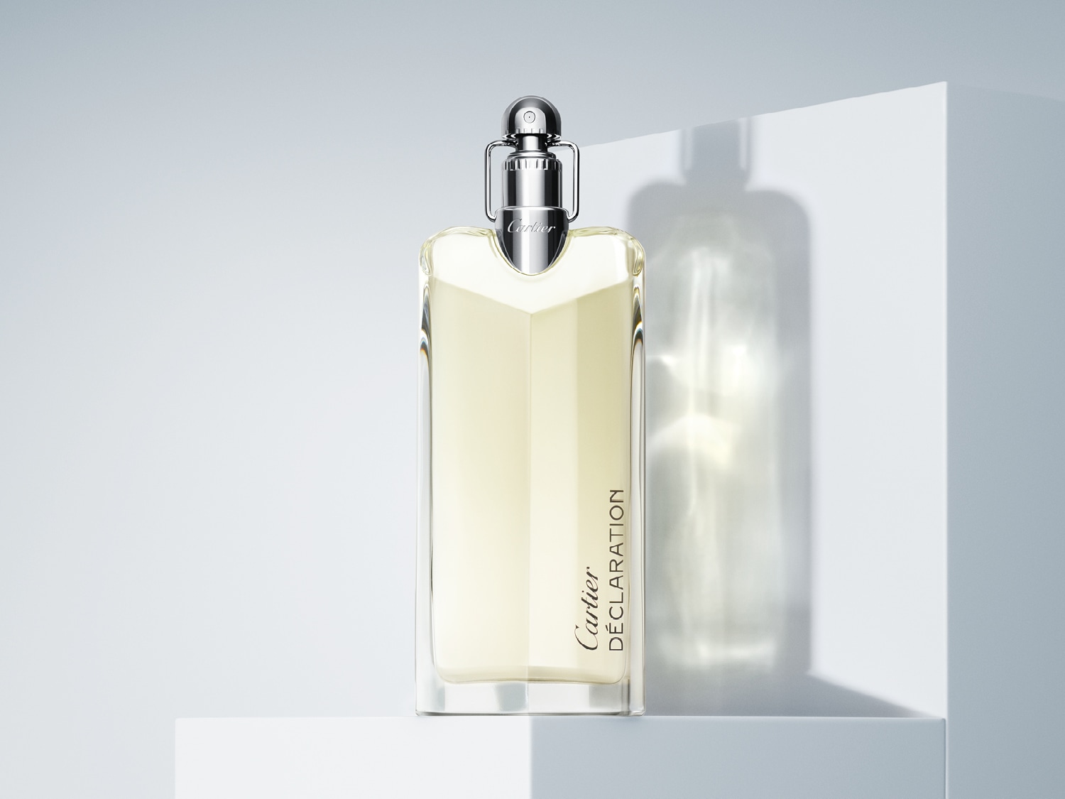 Der Cartier Déclaration Duft präsentiert sich in einem eleganten, durchsichtigen Flakon mit silberfarbenem Verschluss, der auf einem weißen Sockel steht.