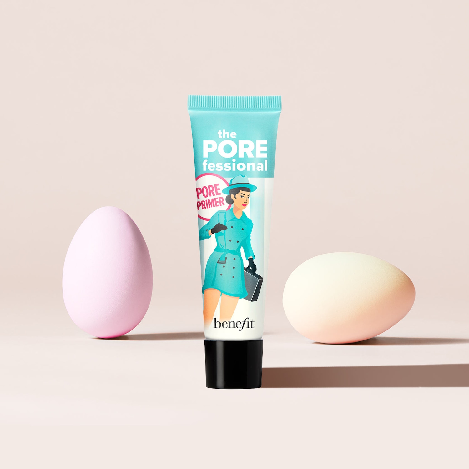Die hellblaue Tube 'The POREfessional' Pore Primer von Benefit mit einer Illustration einer Frau in einem türkisfarbenen Outfit, die eine schwarze Handtasche hält, steht zwischen einem rosa und einem weißen Ei.