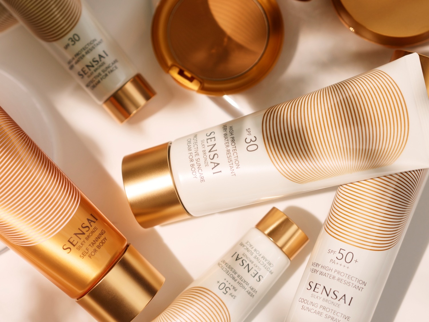 Découvrez la gamme Sensai Silky Bronze : autobronzant pour le corps, crème solaire protectrice pour le visage et le corps, et spray rafraîchissant, tous avec protection SPF 30 et 50.